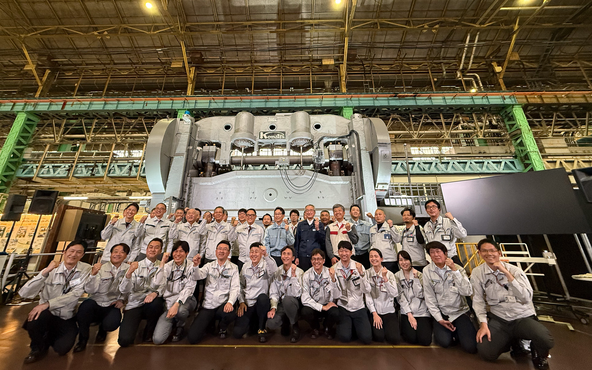 創業期700トンプレス機の前で記念写真