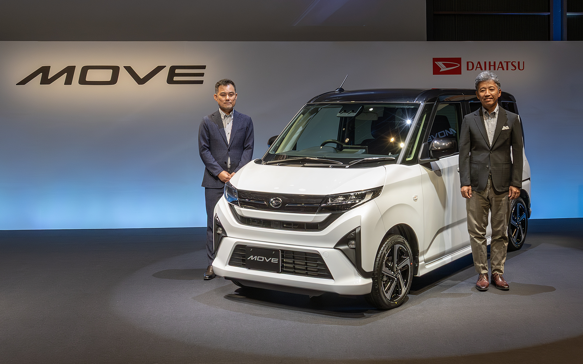 新型ムーヴ発表会にはダイハツ工業 表取締役社長 井上雅宏氏（右）と製品企画部 チーフエンジニアの戸倉宏征氏（左）が登壇。戸倉氏は展示されている実車を「ムーヴらしく動く姿が美しい」「かっこよく凛々しいデザイン」と紹介した