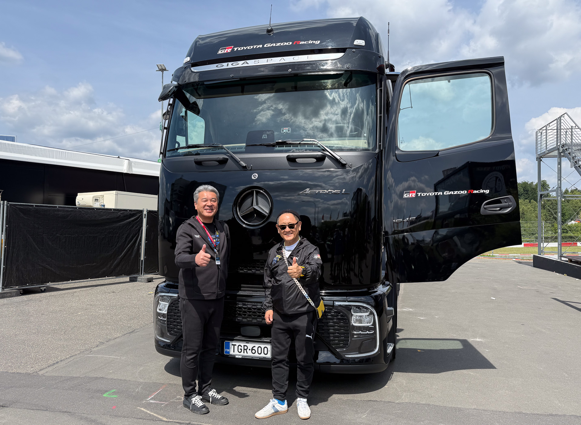 ダイムラートラックの前で記念撮影に応じるトヨタ自動車株式会社 代表取締役会長 豊田章男氏（右）と、同 代表取締役副社長 中嶋裕樹氏（左）