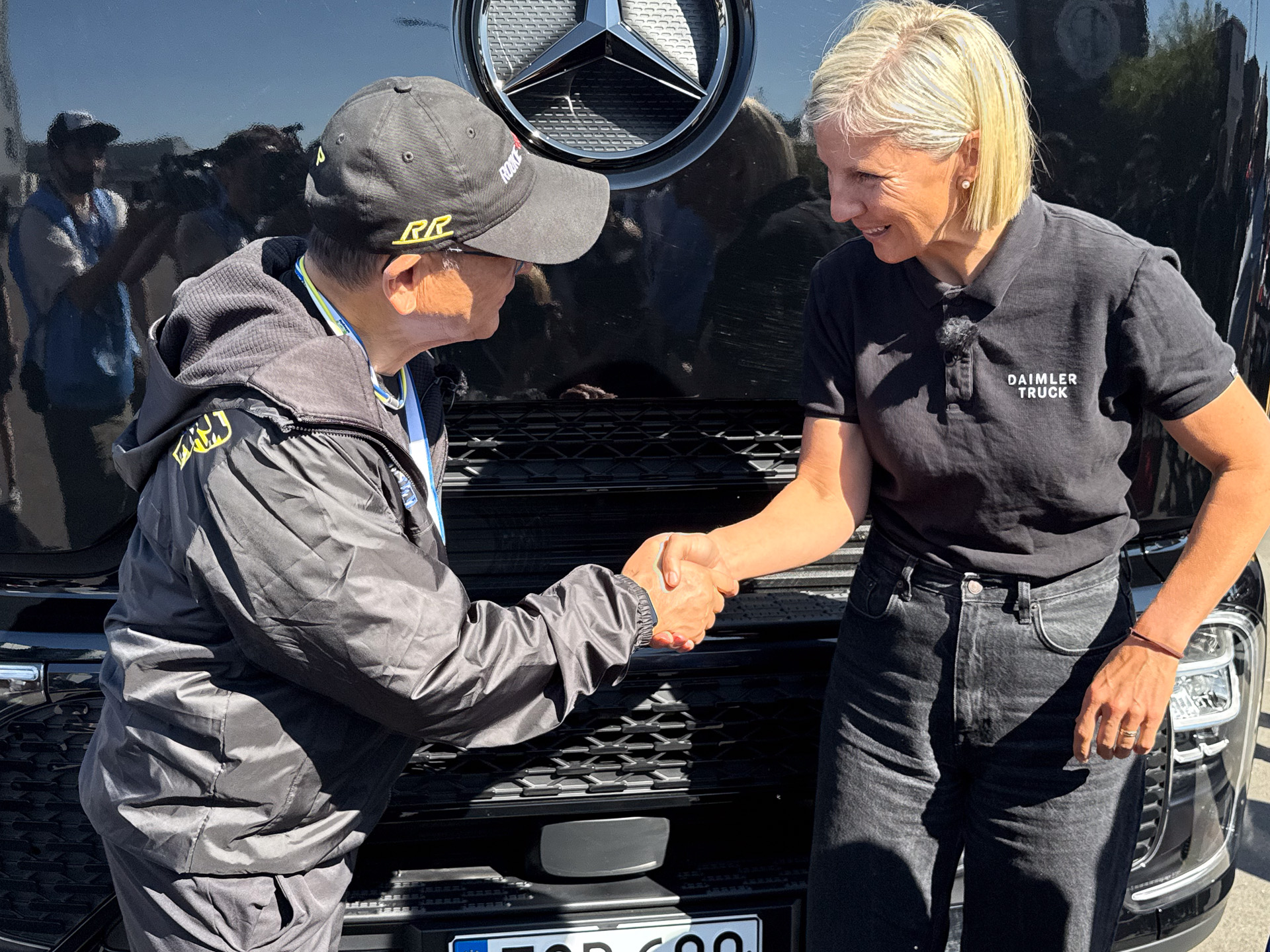 ダイムラートラックの前でカリン・ラドストロムCEOと豊田章男会長が握手