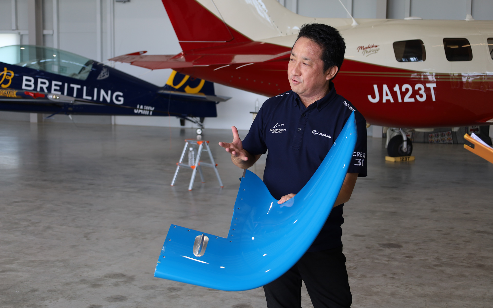 従来のウイングレットを手にする「LEXUS PATHFINDER AIR RACING」の技術コーディネーター 中江雄亮氏、新型ウイングレットは従来のウイングレットと使い分けることで、レース戦略の選択肢を増やす狙いがあるという