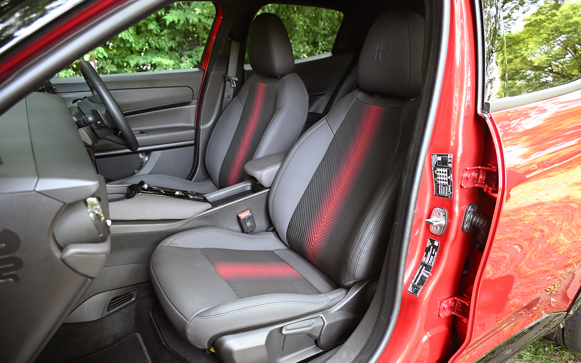ジュニア イブリダ プレミアムのシート表皮はファブリック/テクノレザー。運転席は6ウェイパワーシートとなり、アクティブランバーサポート（マッサージ機能）が付く（助手席は6ウェイマニュアルシート）。シート中央に入る赤いアクセントが輝くネオンのよう