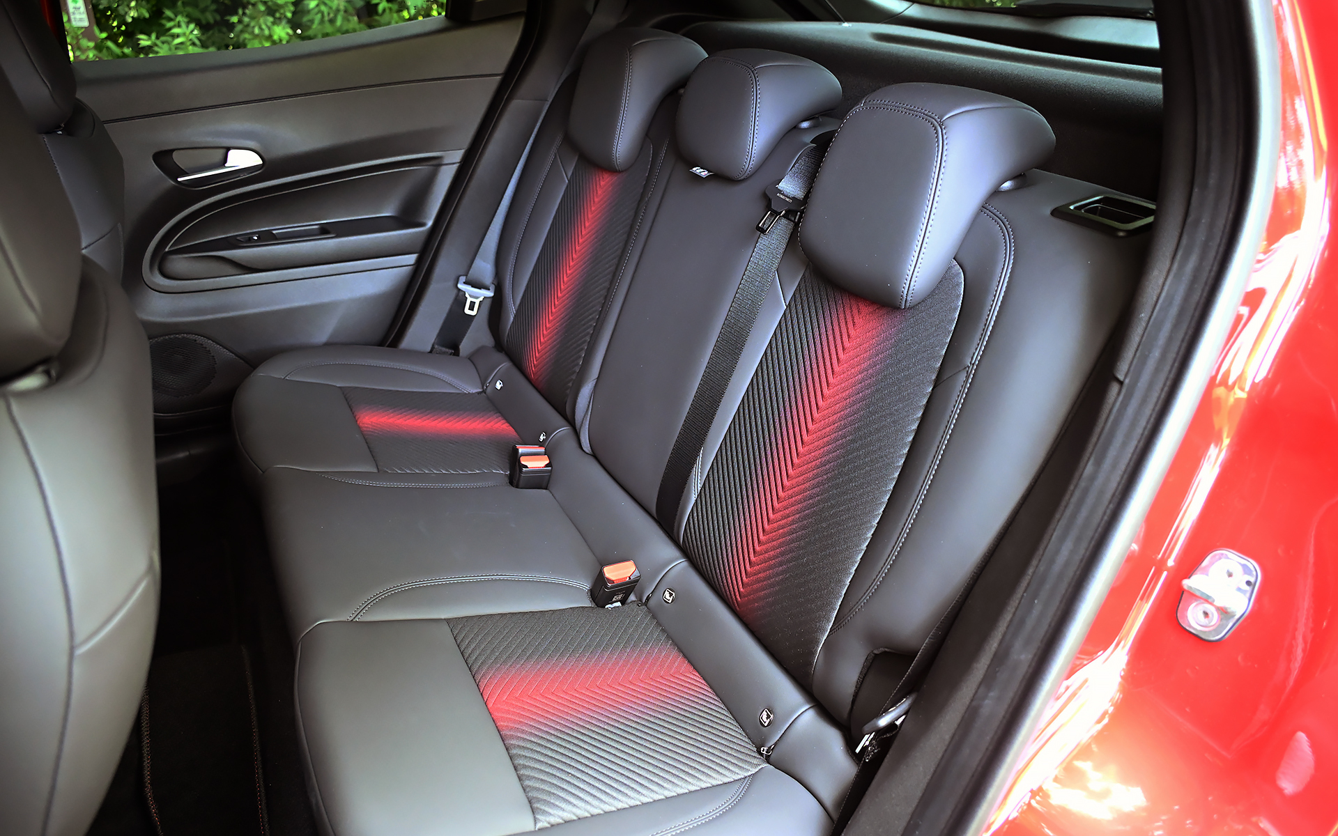 ジュニア イブリダ プレミアムのシート表皮はファブリック/テクノレザー。運転席は6ウェイパワーシートとなり、アクティブランバーサポート（マッサージ機能）が付く（助手席は6ウェイマニュアルシート）。シート中央に入る赤いアクセントが輝くネオンのよう