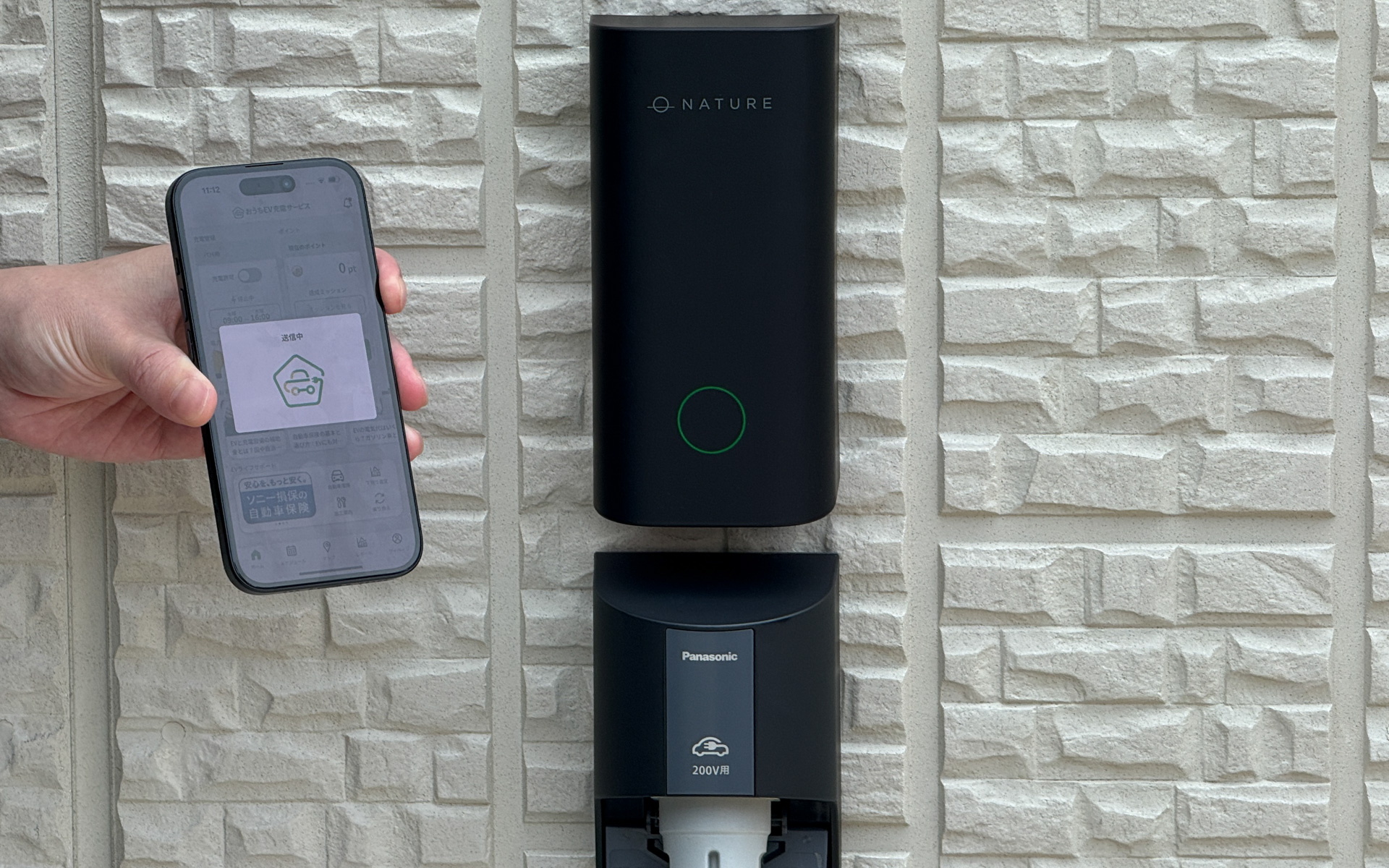 パナソニックの「200V-EVコンセント」の上部に設置された「IoT制御モジュール」。住宅の外壁になじむデザインが採用され、ステータスランプで状態を表示できるほか、LTE内蔵により自宅のWi-Fi連携を不要にした