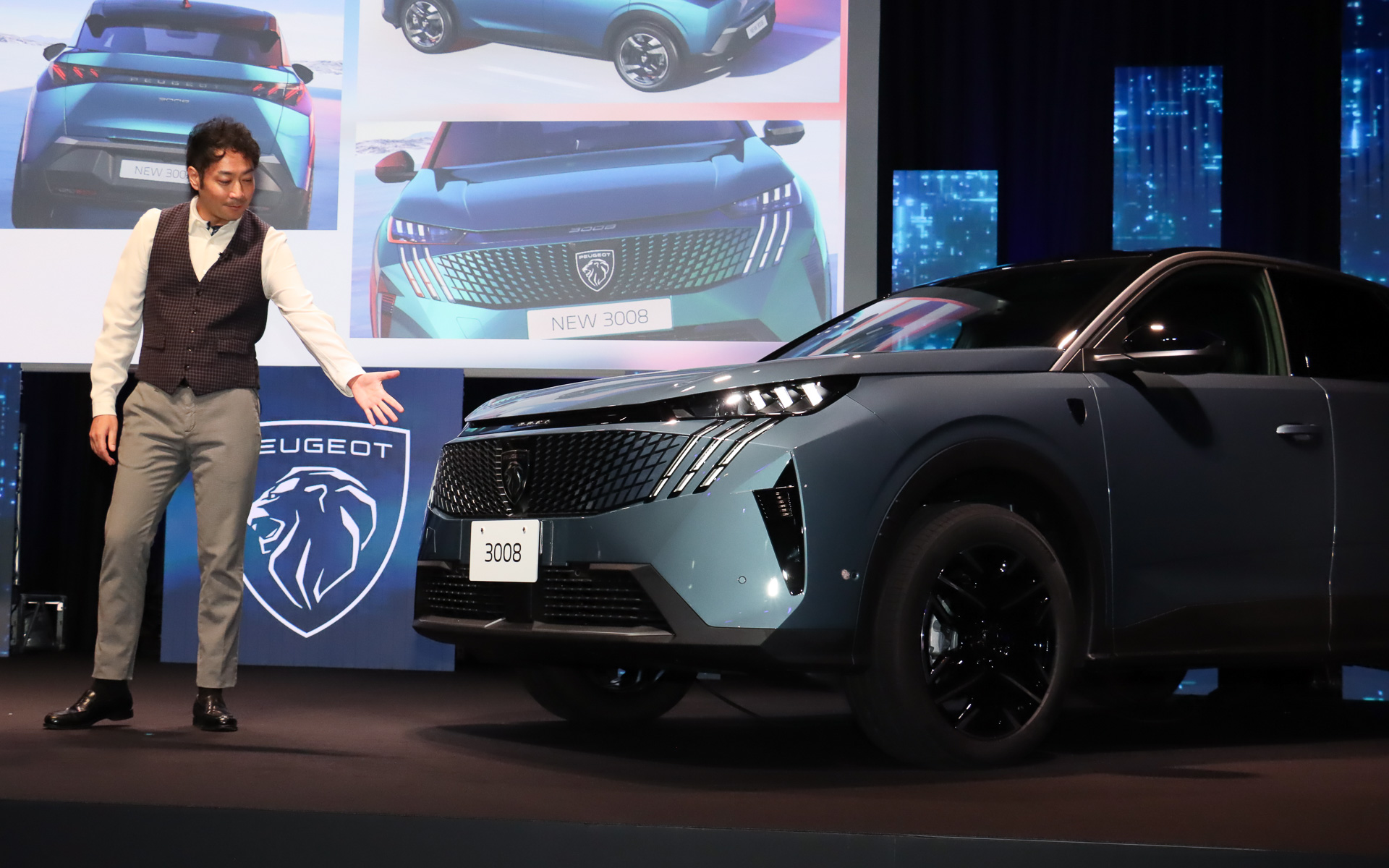 ステージ上に展示された車両を示しながらエクステリアデザインについて説明