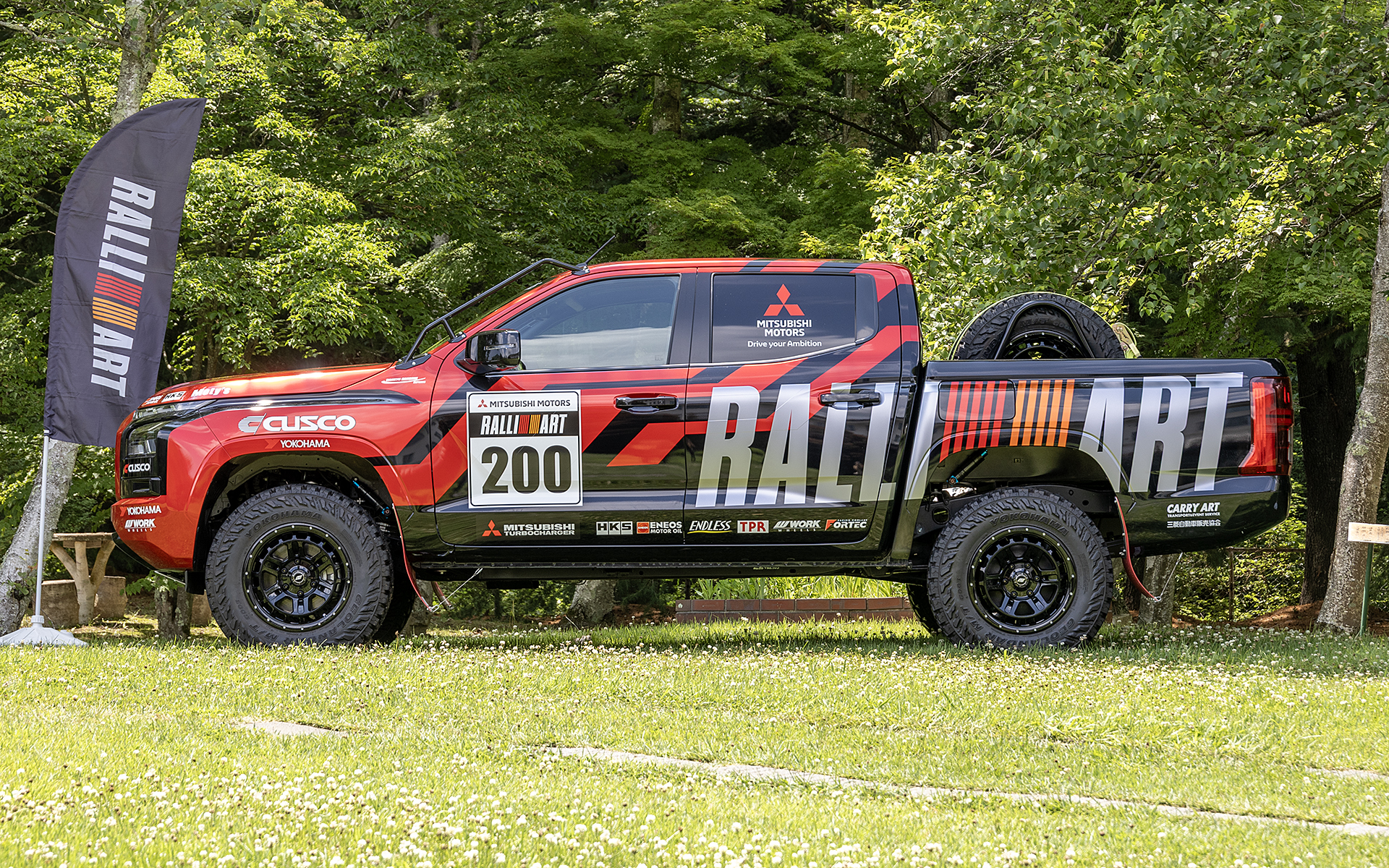 増岡総監督はトライトン 2025ラリー仕様についても少し説明。展示車は日本仕様の市販車。トライトンはデッキ部分が長いが競技車はボディに貼ってあるRALLIARTの「T」のあたりから後を切断し、軽量化を図っている