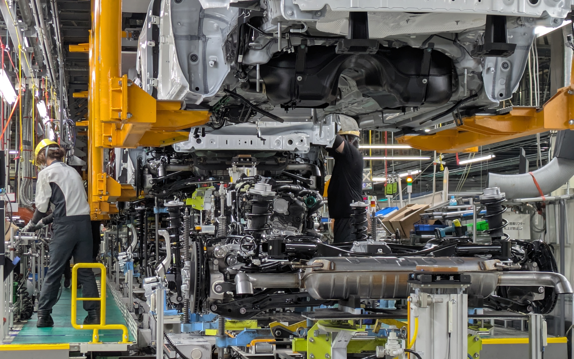 2台の重可搬AGVは所定の位置まで進むとリフトアップで部品を高い位置へ移動し、作業員が最終位置に合わせながら、ボディへと組み込みボルト止めを行なう。AGV自体が重い部品をリフトアップしてくれるので作業員の負担も軽減している