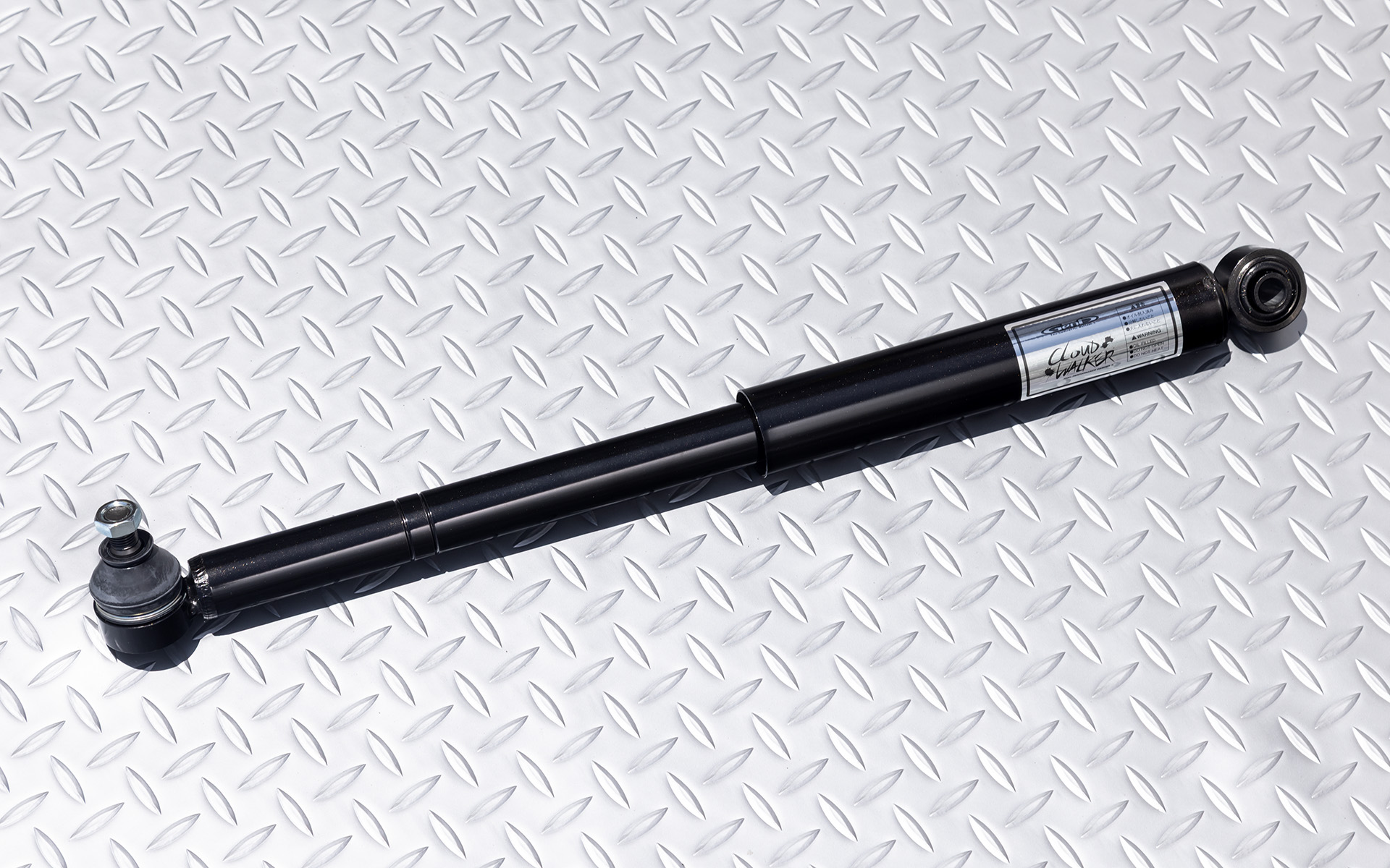 現行ジムニーには純正でステアリングダンパーが付いているが、リフトアップやタイヤ、ホイールのインチアップをすると容量が不足する場合もある。写真の部品はそのときのための強化品である「ハイパフォーマンスステアリングダンパー」。価格は2万3100円