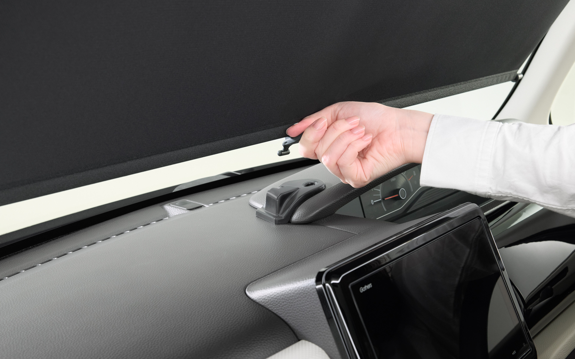 内蔵サンシェードはノブを片手でつまんで引き出し、ダッシュボード上のホルダーに掛けるだけの簡単操作