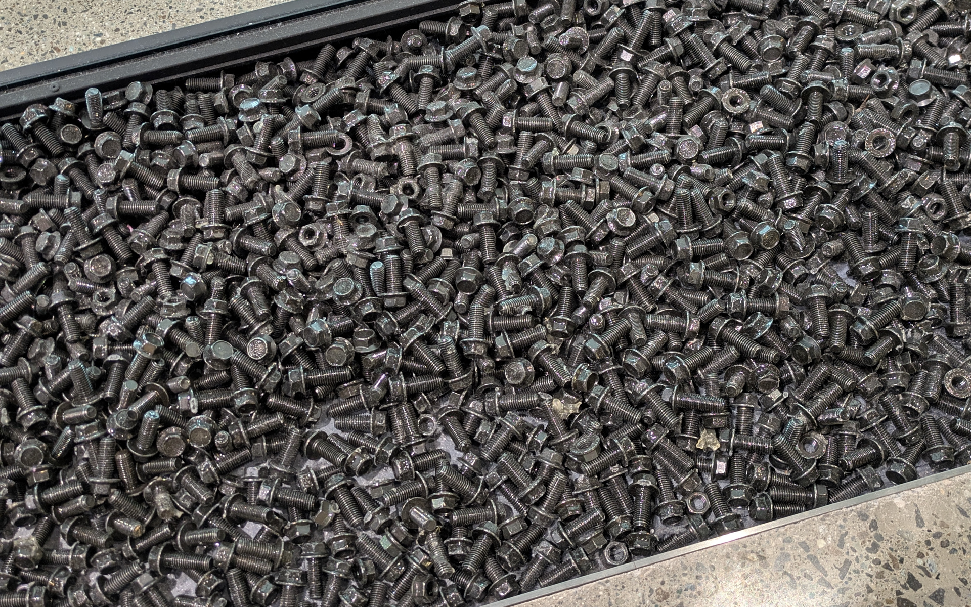 オブジェの下を見ると黒い小石かと思いきやすべてボルトとナットで埋め尽くされています