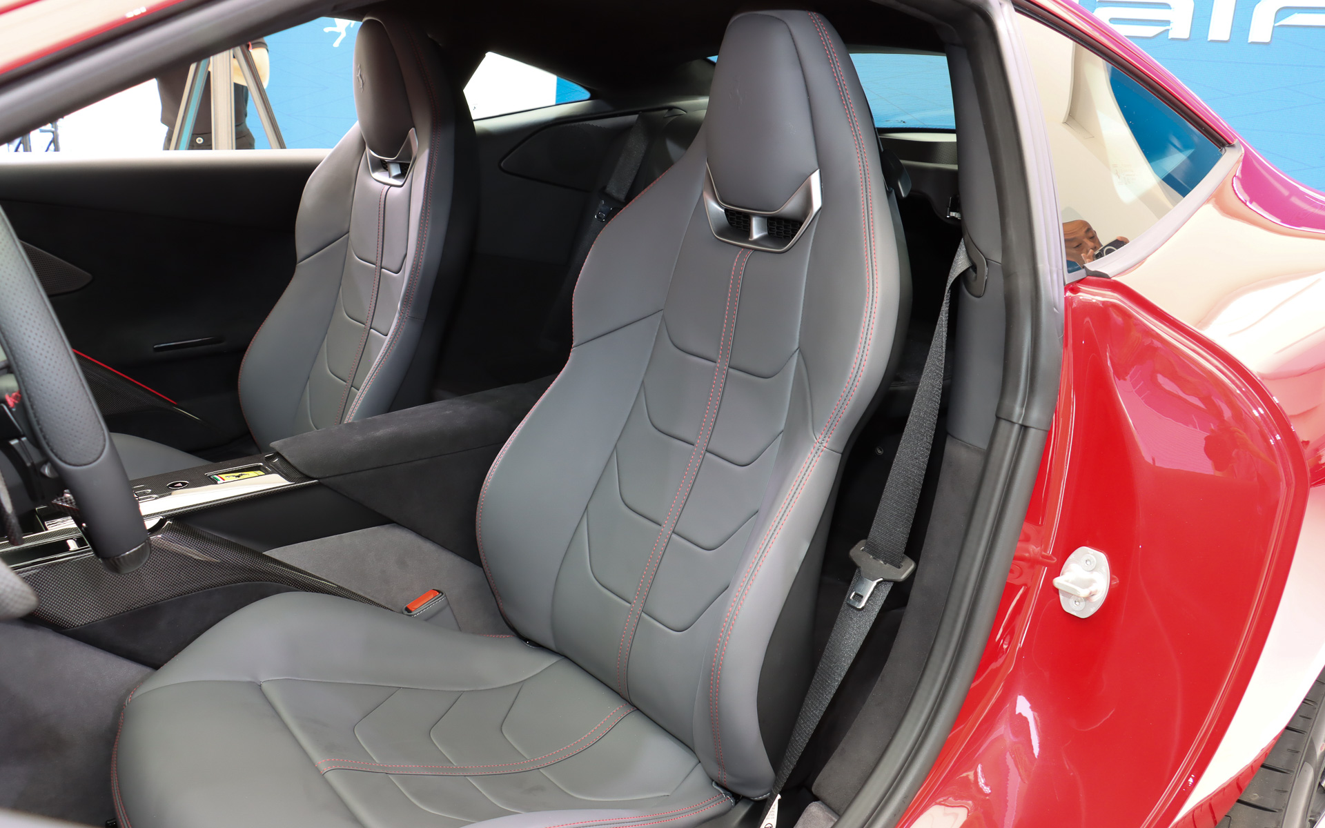 レッドステッチが施されたレザーシートを前席に設定。ヘッドレスト側面のレバーを操作してシートバックを前方に倒し、後席にアクセスする