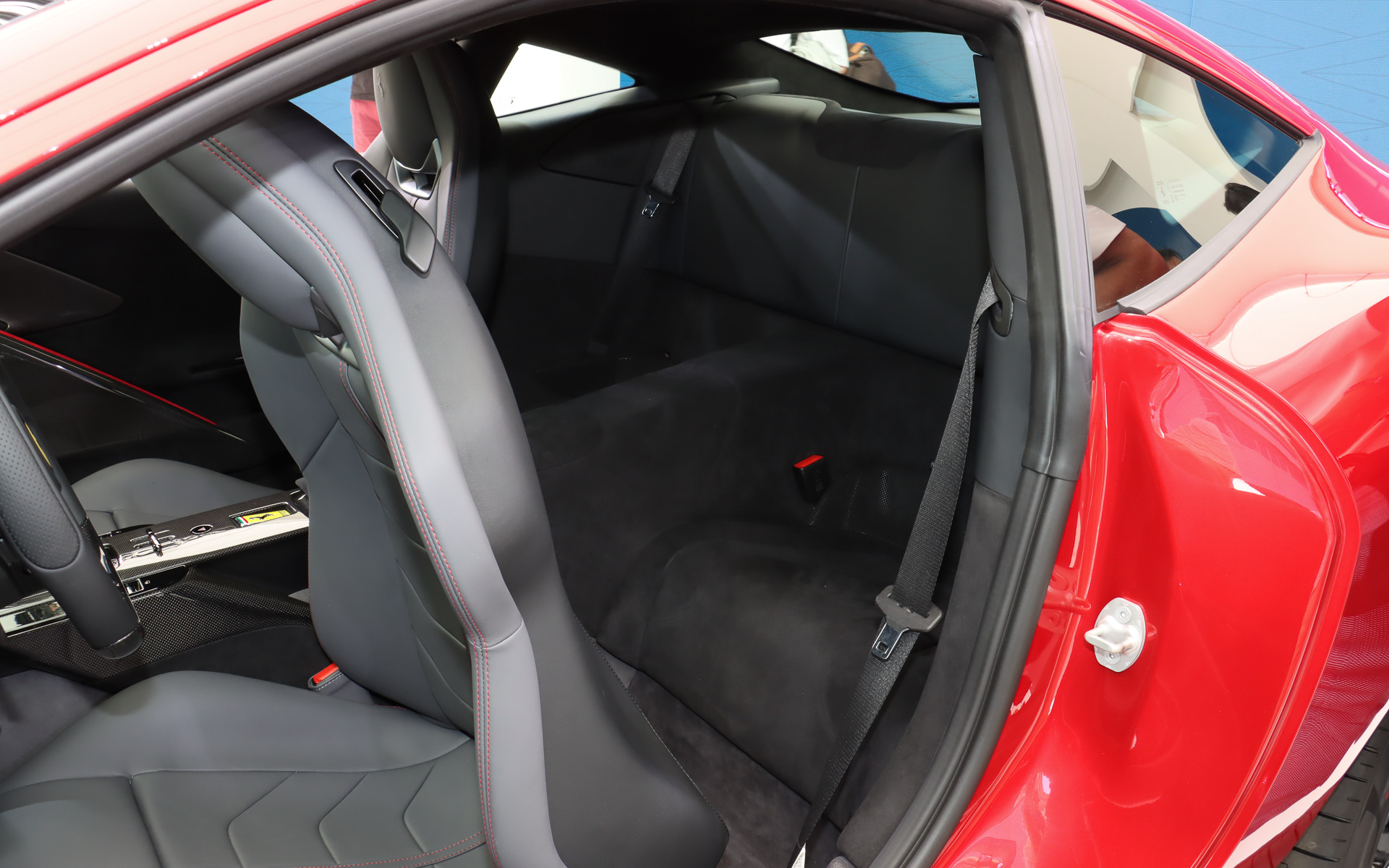 レッドステッチが施されたレザーシートを前席に設定。ヘッドレスト側面のレバーを操作してシートバックを前方に倒し、後席にアクセスする