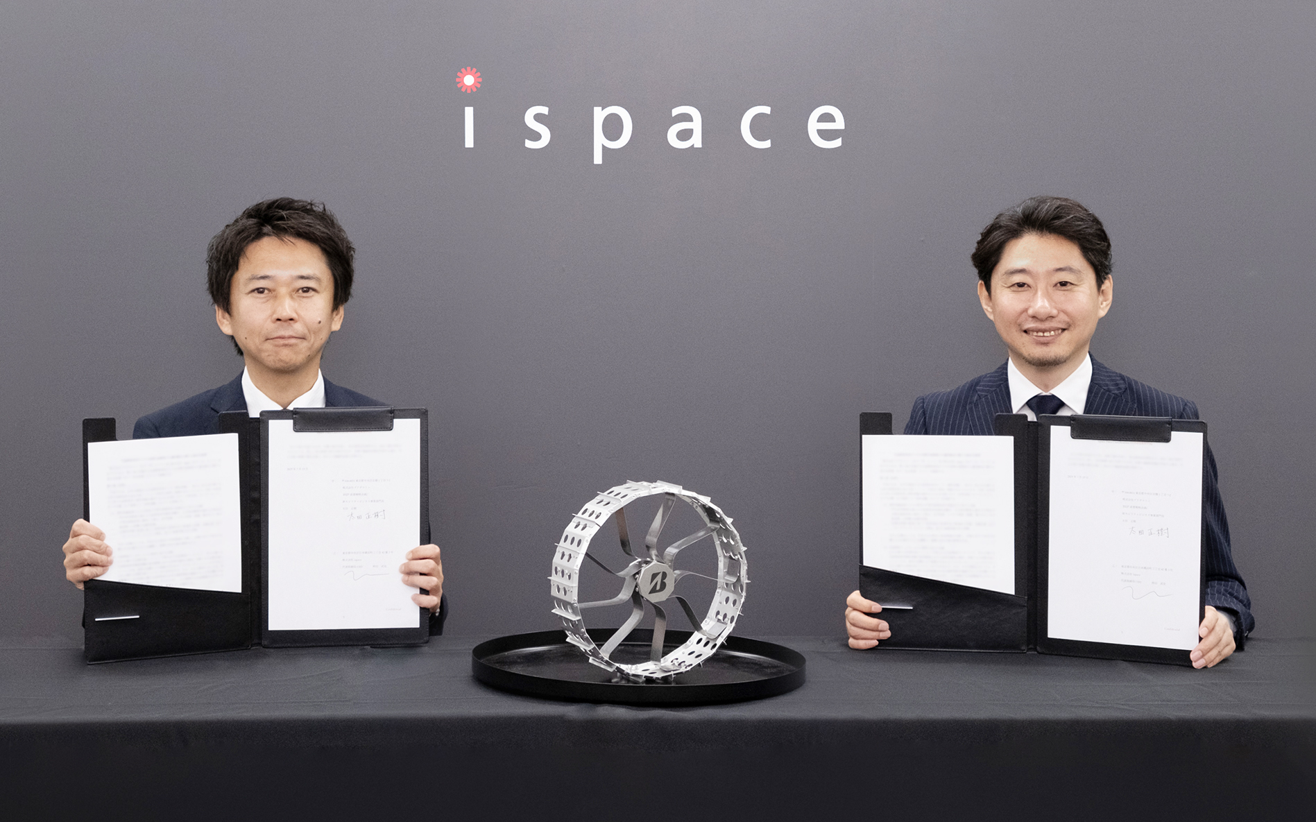 締結式のようす。写真左は株式会社ブリヂストン BSJP直需タイヤ戦略企画/新モビリティ事業部門長 太田正樹氏、右は株式会社ispace 代表取締役CEO & Founder 袴田武史氏