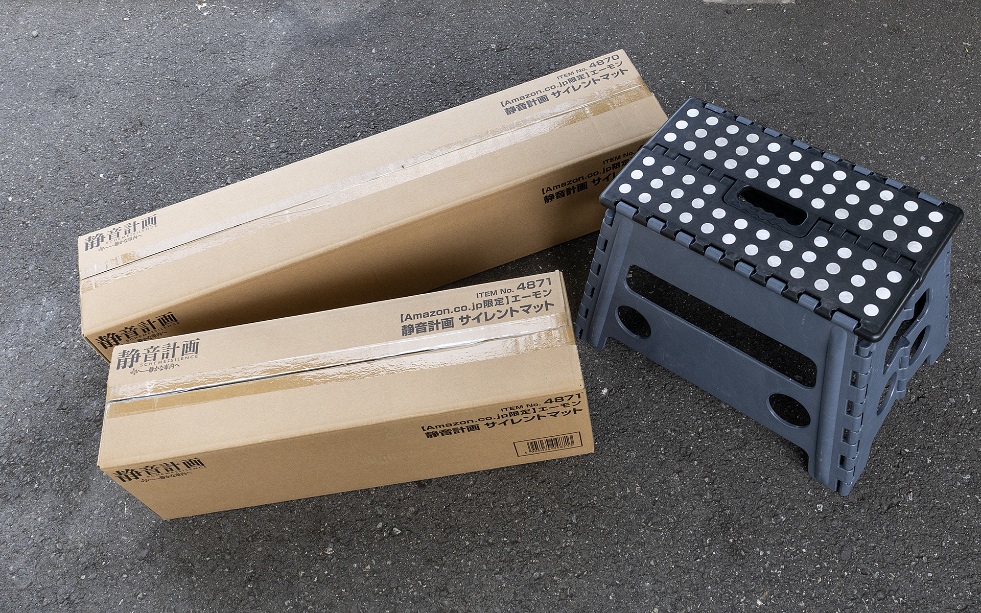 サイレントマットはAmazon限定商品。このような梱包で届く。どちらも大きいので、宅配ボックスでは受け取りが難しそう。ちなみに写真右側の折りたたみ踏み台は、サイズ比較用に置いている。踏み台のサイズは450×320×300mm（幅×高さ×奥行き）