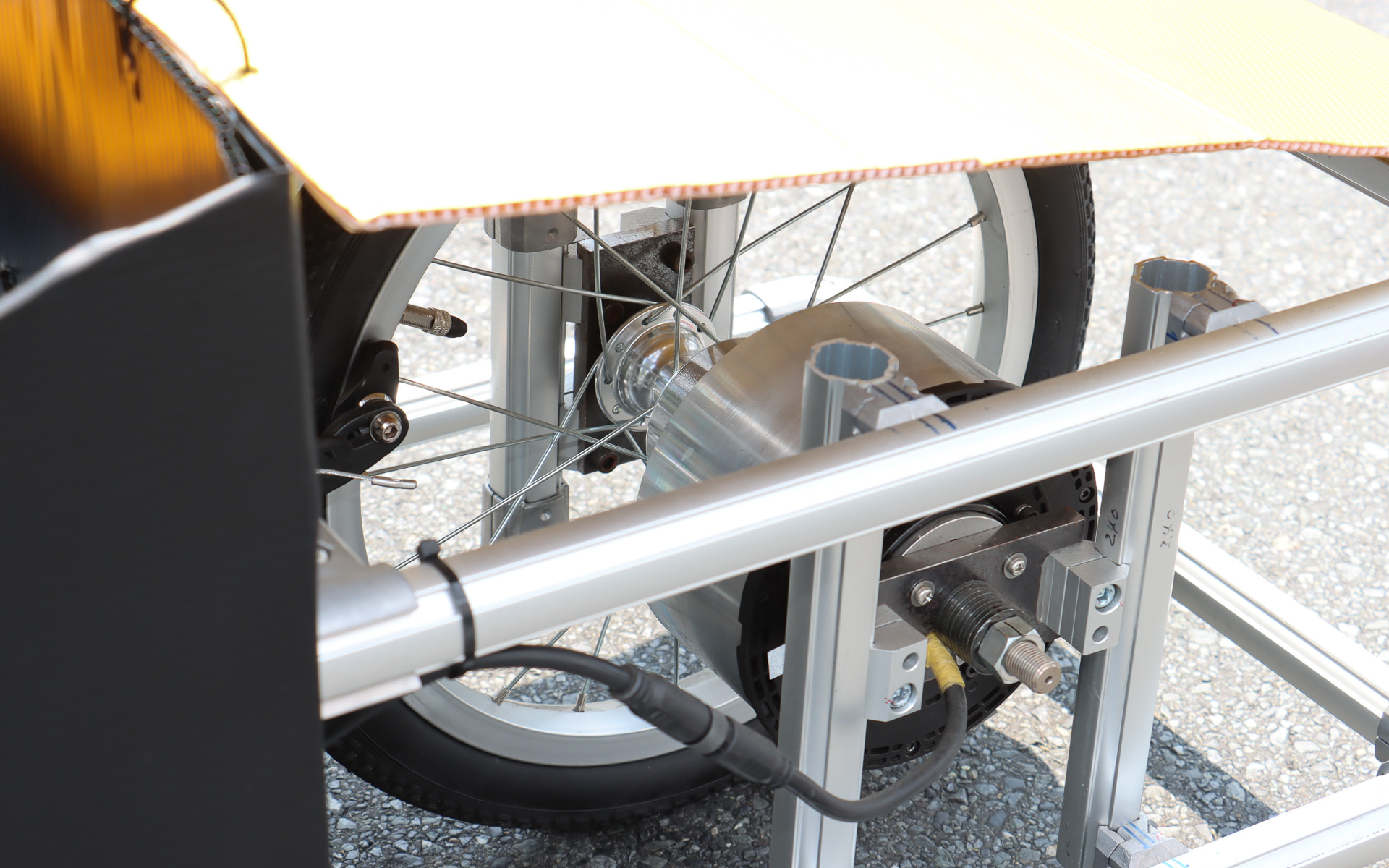 コアレスモーター製のインホイールモーターでリアタイヤを駆動。スーパーキャパシタで昇圧させた48Vの電力によって最高速60km/hで走行することが当初予定だった