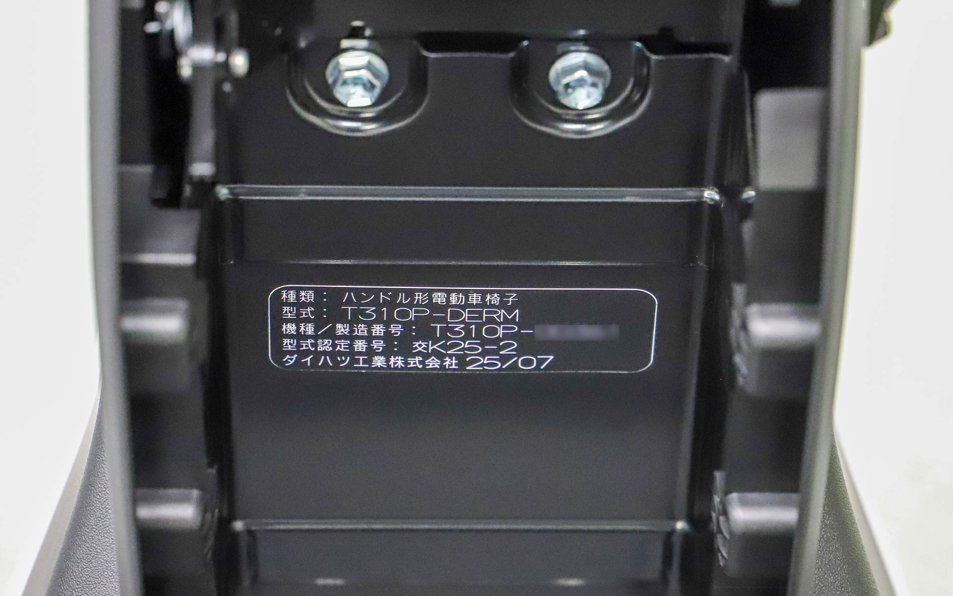バッテリを外すとコーションプレートが付いていた。型式は「T310P-DERM」で、型式認定を取得していることが分かる