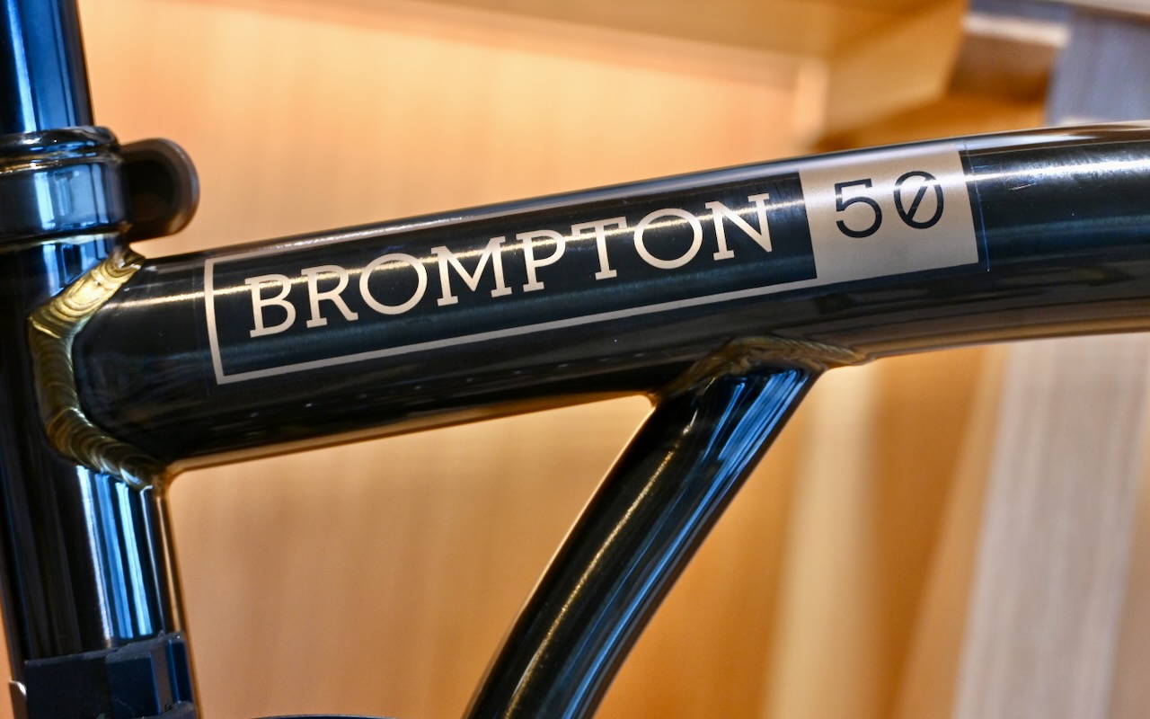 フレームのブロンプトン50のロゴとともに、サドルやバッグ、泥除けなど各部に50のモノグラムが入る