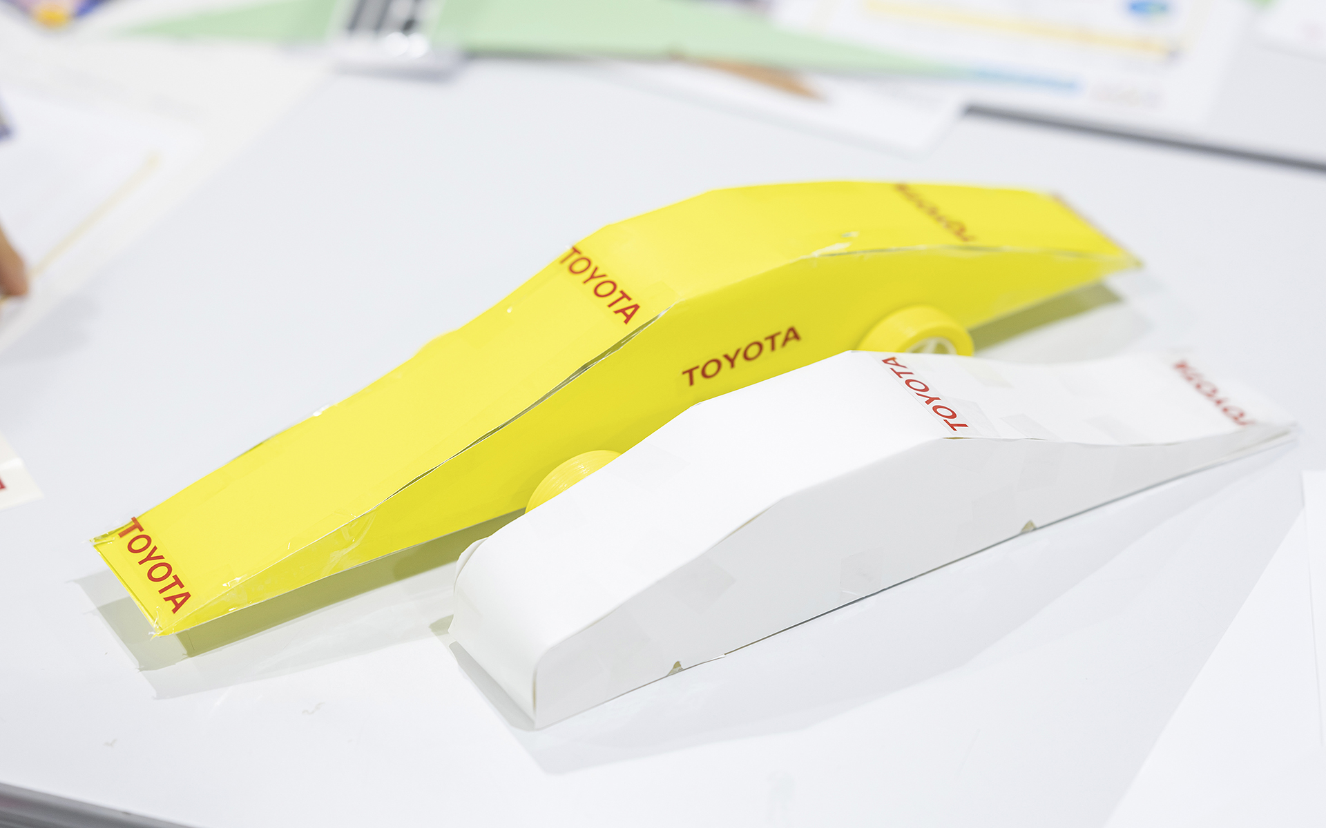 子供たちが作ったクルマの例。手前が1回目。黄色のクルマはアドバイスをもらって作った2回目のもの