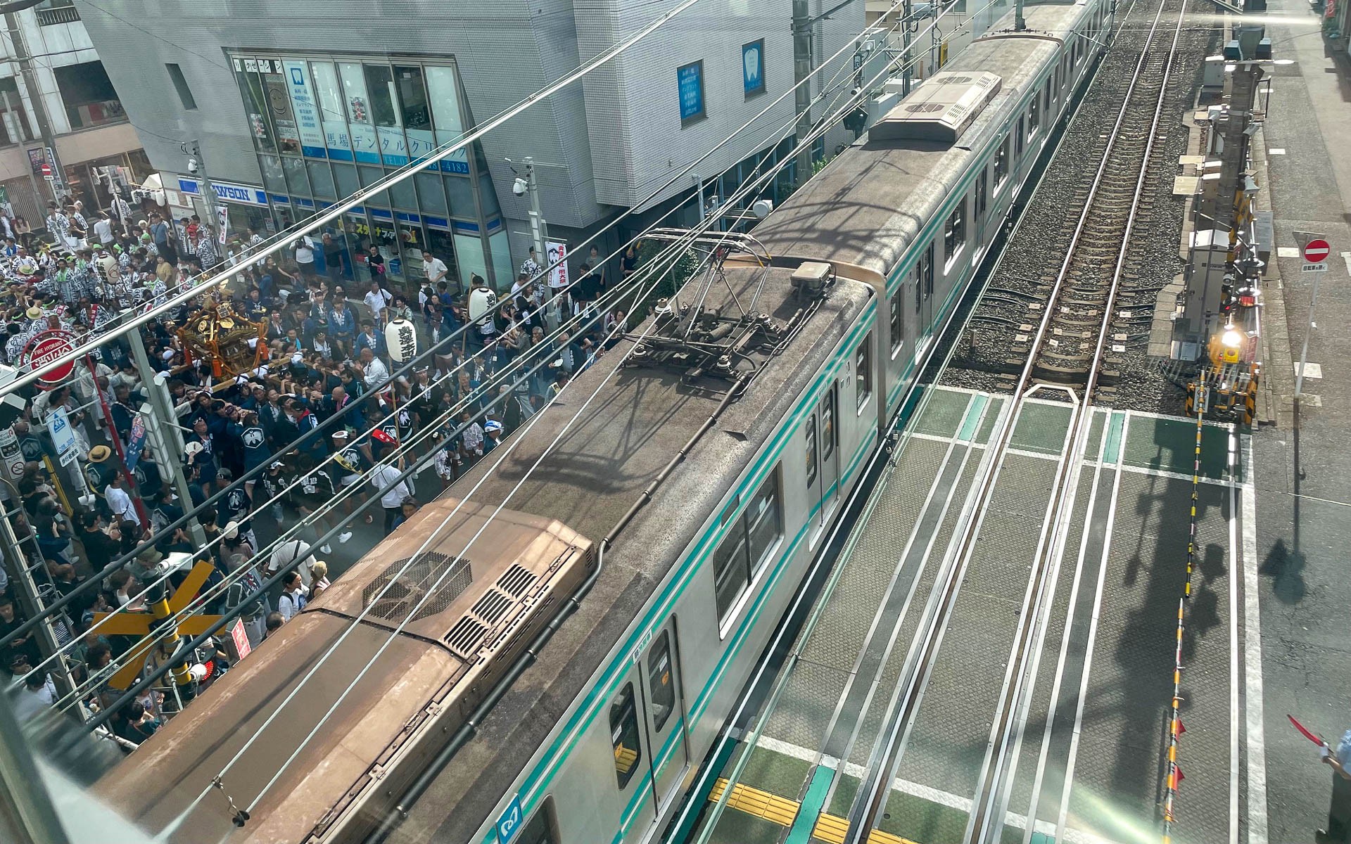 踏切で電車を待つ神輿。奥沢神社に行くには踏切を渡らなければならない。ヒヤヒヤしていたがちゃんと駅員がダイヤを見て指示していた。珍しい光景だった