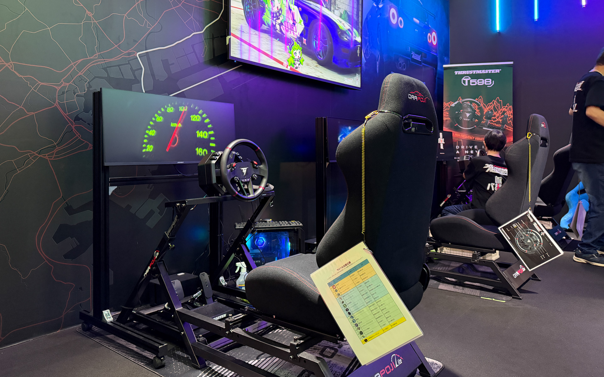 試遊台には、長谷川工業の最新型レーシングシミュレーター「DRAPOJI Lite」にステアリングコントローラー「Thrustmaster T598」で操作できるようにしている