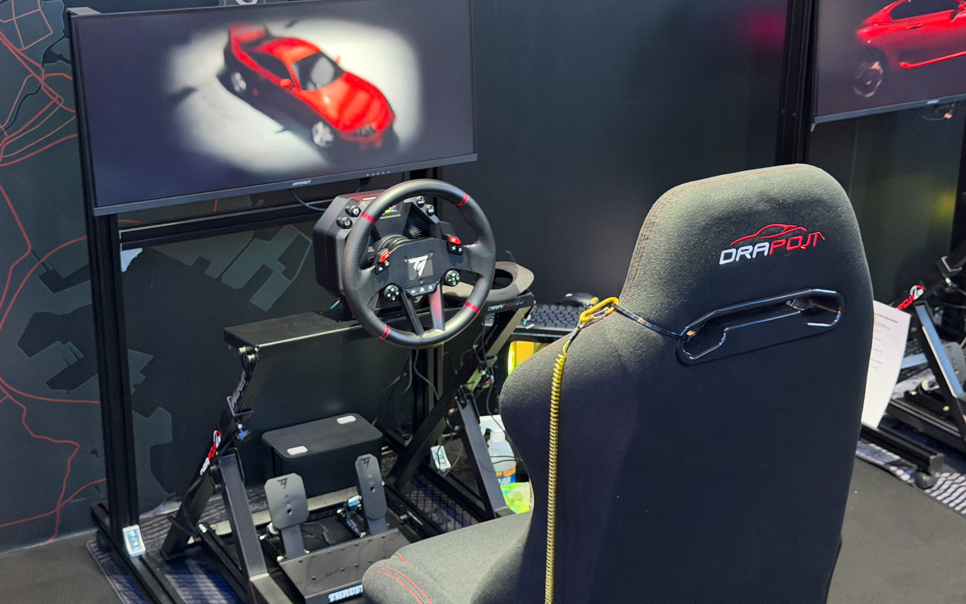 試遊台には、長谷川工業の最新型レーシングシミュレーター「DRAPOJI Lite」にステアリングコントローラー「Thrustmaster T598」で操作できるようにしている