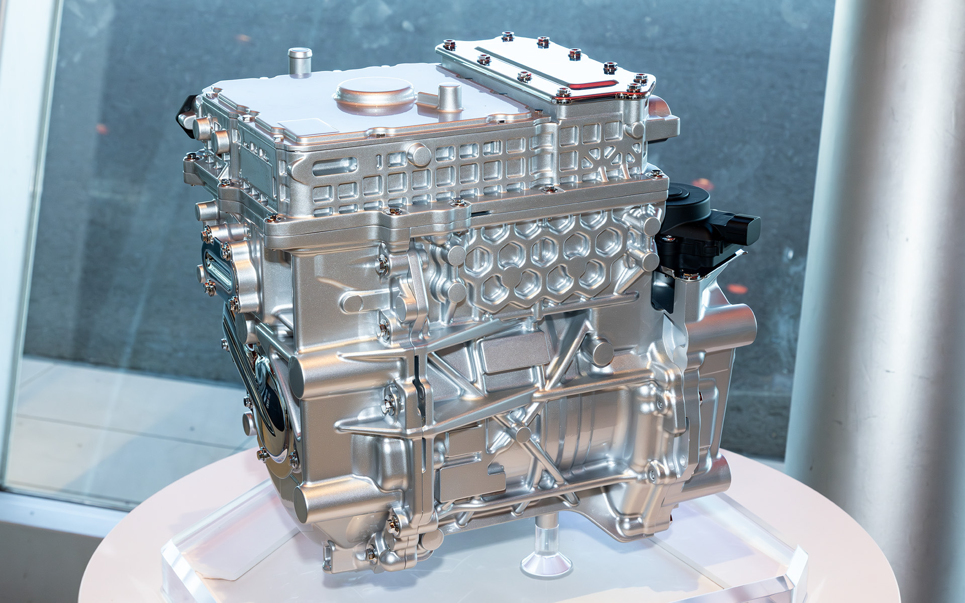 モーターとインバータ、減速機を一体にした3-in-1電動パワートレイン。上部がインバータ、その下がモーター、横に出ている丸い部分が減速機になる