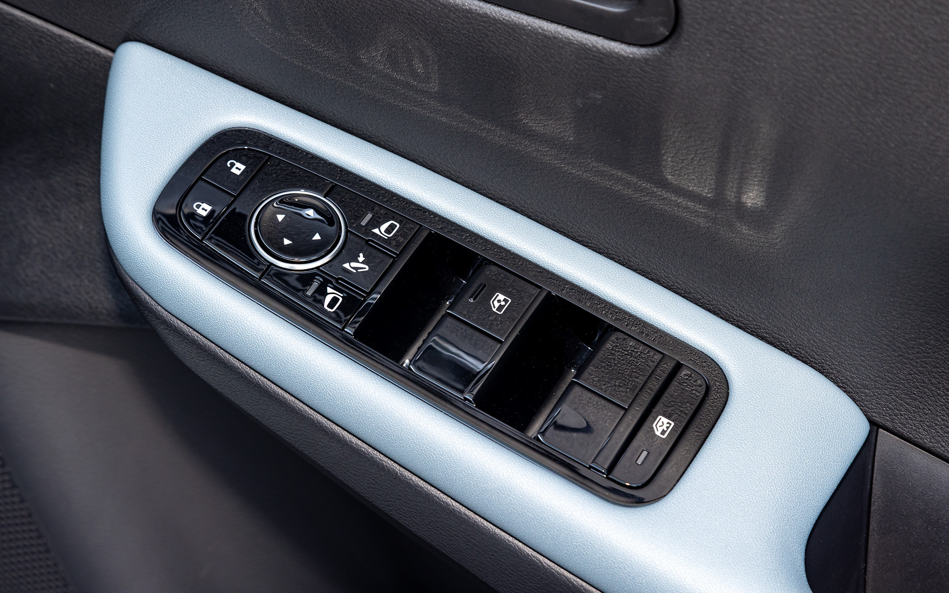 アームレスト部にはパワーウィンドウなどのスイッチ。ピアノブラックのためシボが反射して妙な見え具合になっている