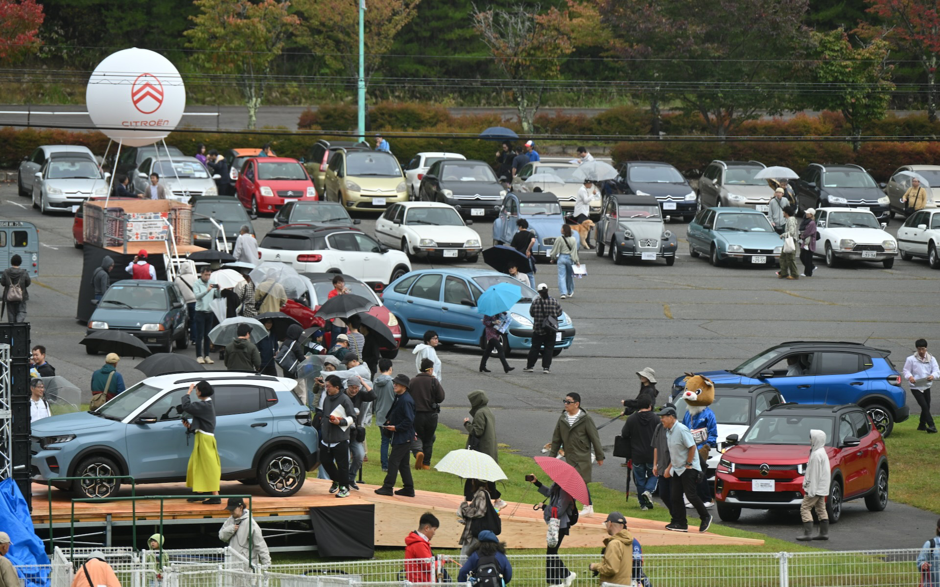 新型C3の発表（手前）に参加者らは興味津々。後方には新旧シトロエンがずらりと並ぶ