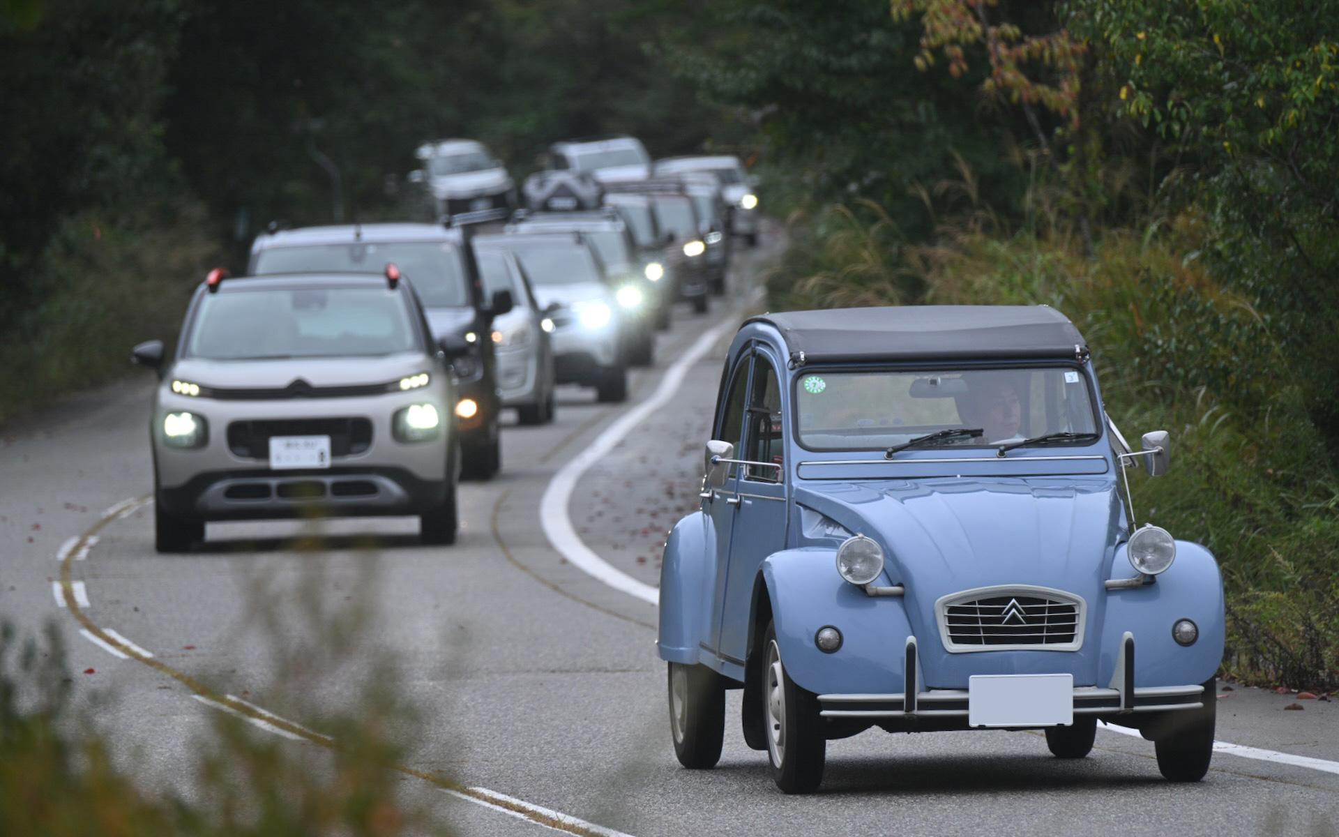 峠道を会場に向かって登ってくる2CVをはじめとする新旧シトロエンの参加車両たち。空冷のバタバタというサウンドが辺りに響き渡るのがいい