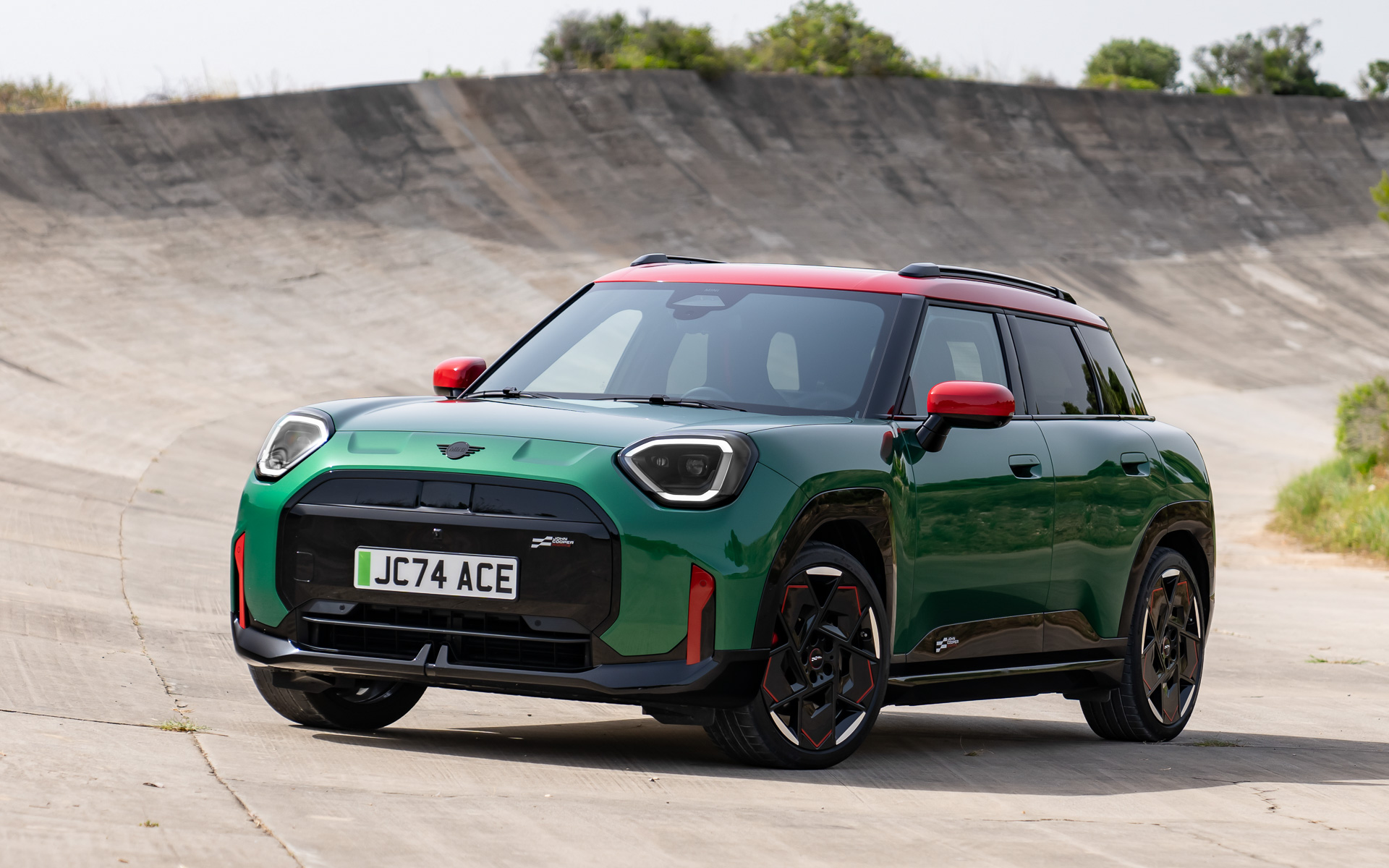 ジョン・クーパー・ワークス エースマン Eはフロントグリルに「ハイグロス・ブラック・フレーム」を採用。空気抵抗を大幅に抑制するフロントバンパーとダウンフォースを生み出すリアスポイラーも装着している