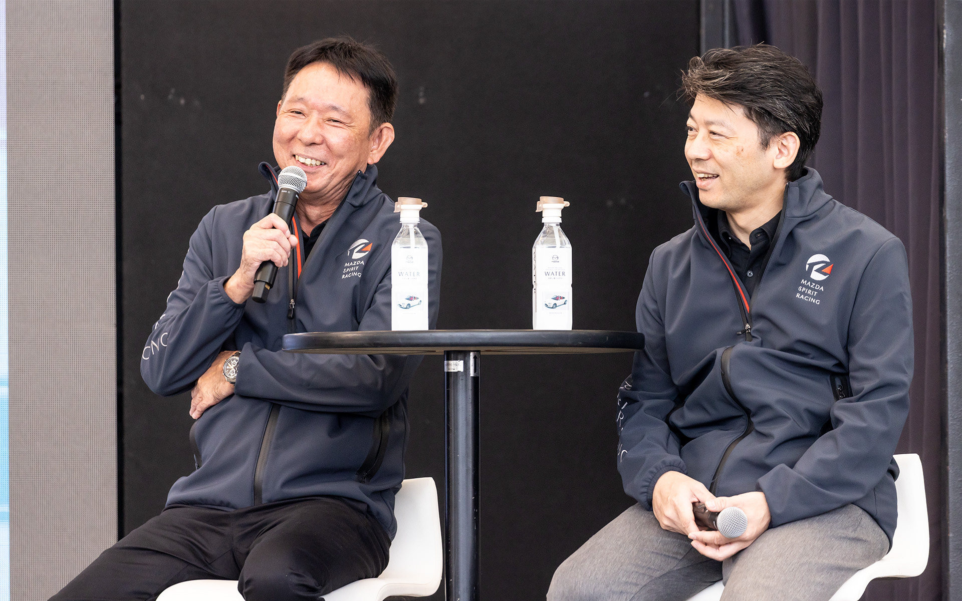 2.0リッターエンジン搭載モデル「MAZDA SPIRIT RACING ロードスター」と「MAZDA SPIRIT RACING ロードスター 12R」ついてのトークショーの真っ最中。ピストン西沢氏が試乗の感想を語り、マツダからは開発や製造の裏話が明らかにされた