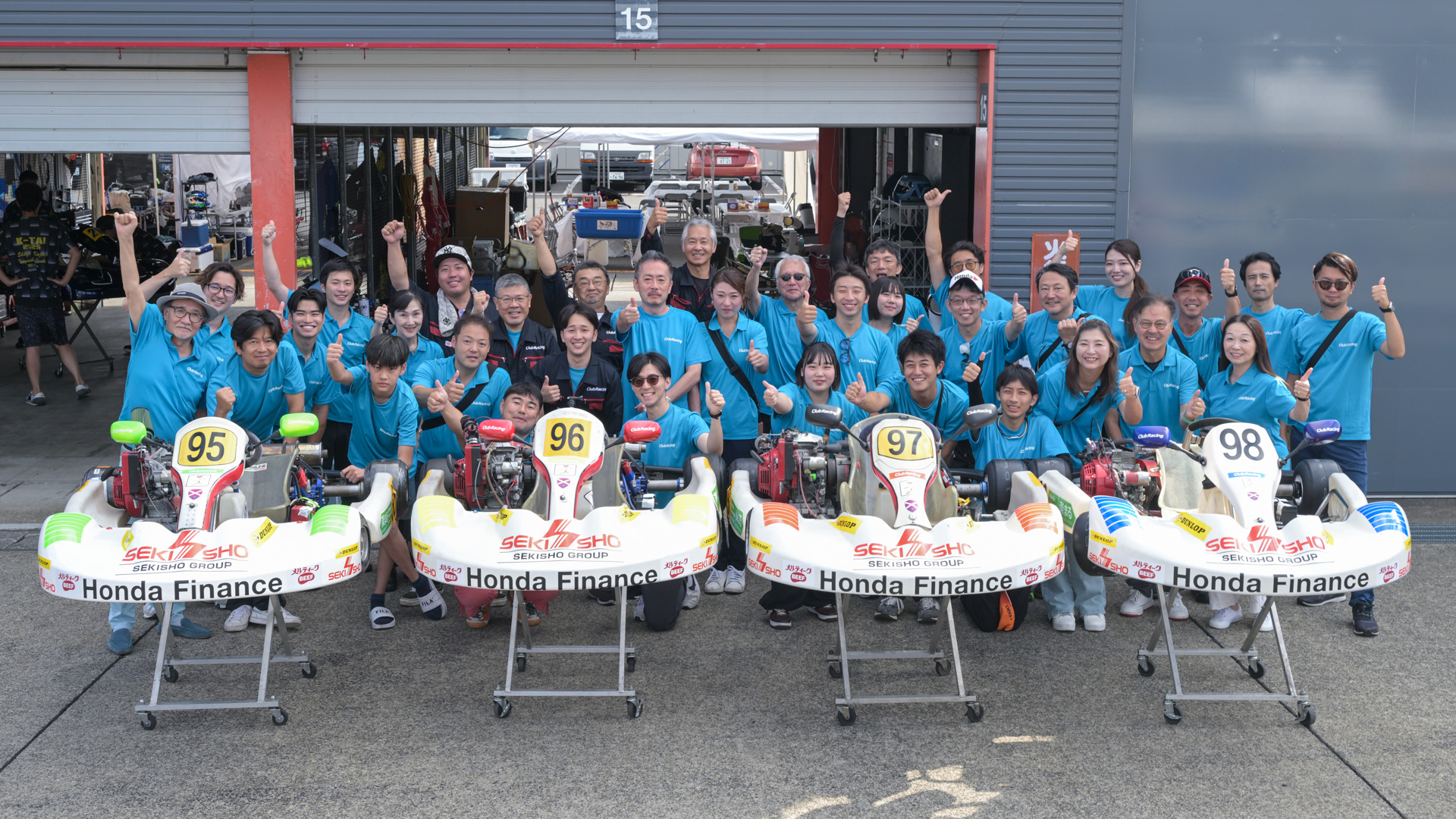 2025年のクラブレーシングの面々。中央後方の創始者の中部博さんをはじめ、山崎憲治さん、片岡英明さん、鈴木健一さん、工藤貴広さんらベテランから、橋本隆さん、西川省吾さん、黒木美珠さん、瀬イオナさんら若手のジャーナリスト、自動車メディアの編集者やその関係者などで構成されている