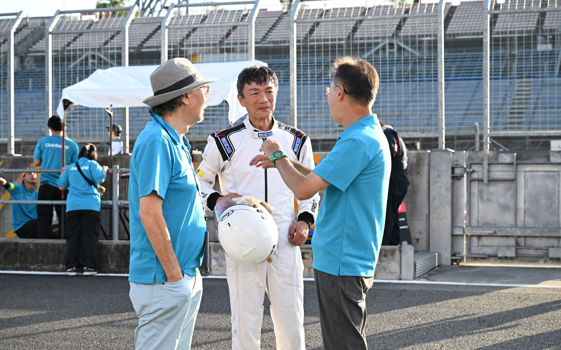 クラブレーシング名誉会長の山崎憲治さん（左）と現会長の片岡英明さん（右）に労ってもらう岡本幸一郎（中央）