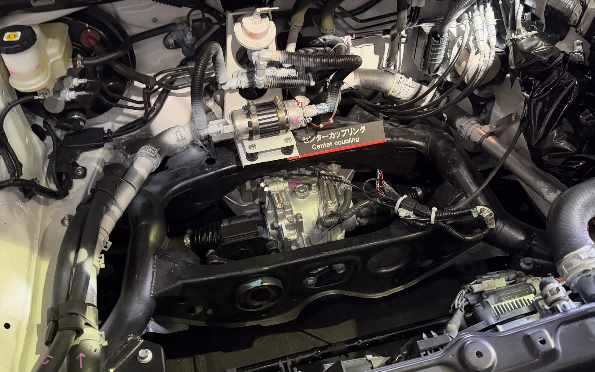 フロント部に配置されたセンターカップリング、ジェイテクト製の電子制御カップリングでGRヤリスと同じITCC。コントロールソフトは変更しているとのことだが、ハードウェアは同じ。東京オートサロン2025で世界初公開されたときのもので、現在は巨大な送風ファンが上に配置されているため直接見ることはできない