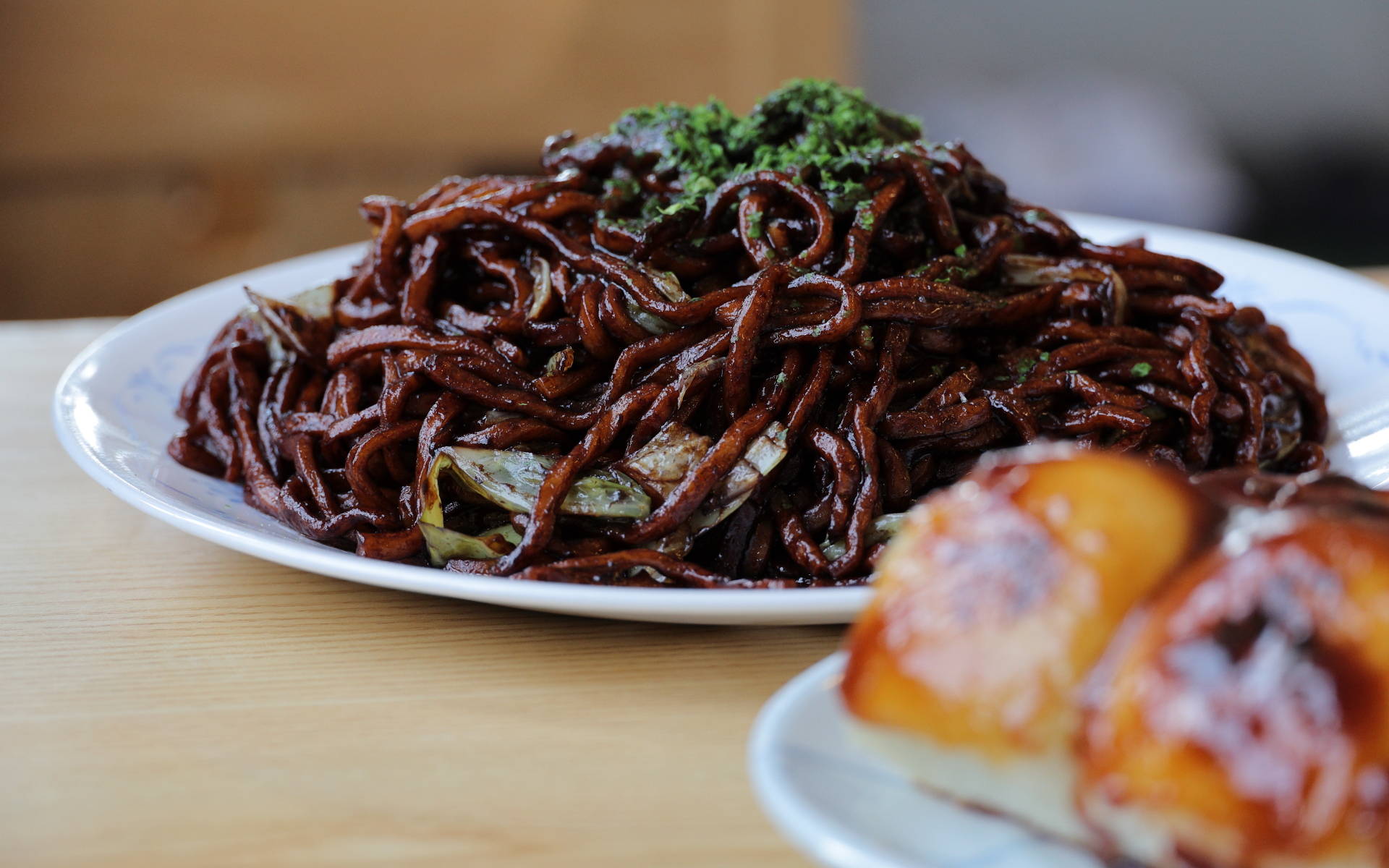 出てきた焼きそばは想像していたより黒い！　麺はもちもちで食べごたえがあっておいしかったし、ソースはなんだか懐かしい味で“これこれ！”という感じだった。焼きそばと一緒にこちらも名物だという焼きまんじゅうを注文。ふんわりもちもちした食感と甘辛い餡がおいしかった