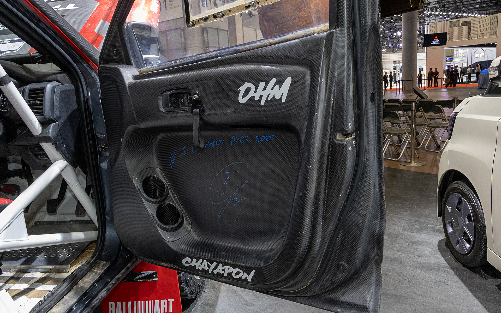 外装パーツの多くはカーボン製に交換されている。運転席側ドアにはドライバーのサインが入っている