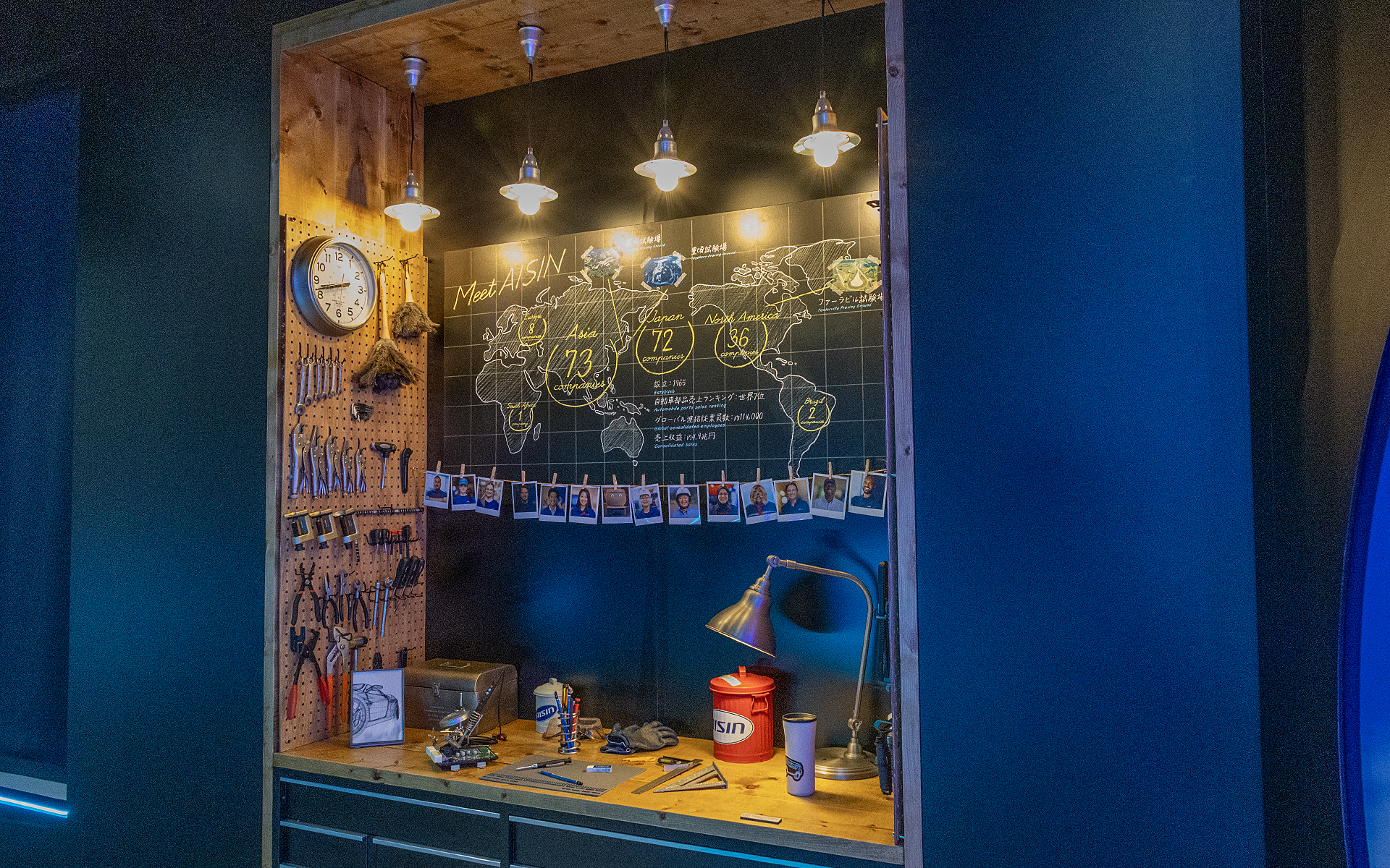 「A’s GARAGE」は小物遣いも見ていて楽しいもの。ここは細かい作業を行なうような机をイメージしたもの。壁には世界各国のアイシンの拠点や、そこで働く人の写真の飾られている