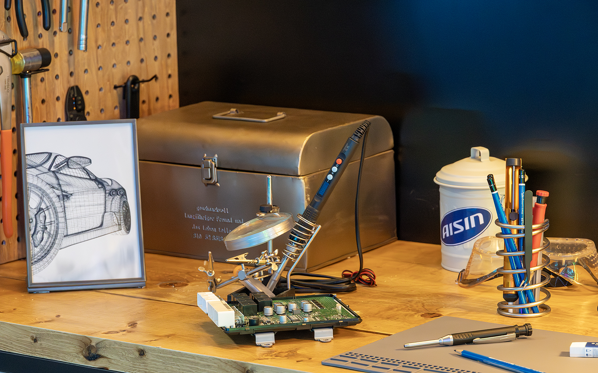 壁には工具がかけられる。机の上にははんだごてと何かの制御用ユニットが置かれていて、博士が「ハイラックスサーフに新しい機能をするための作業中」というストーリーを感じる