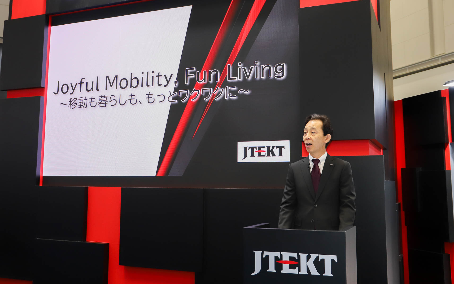 ジェイテクトブースのテーマ「Joyful Mobility, Fun Living ～移動も暮らしも、もっとワクワクに～」を紹介する株式会社ジェイテクト 取締役社長 近藤禎人氏