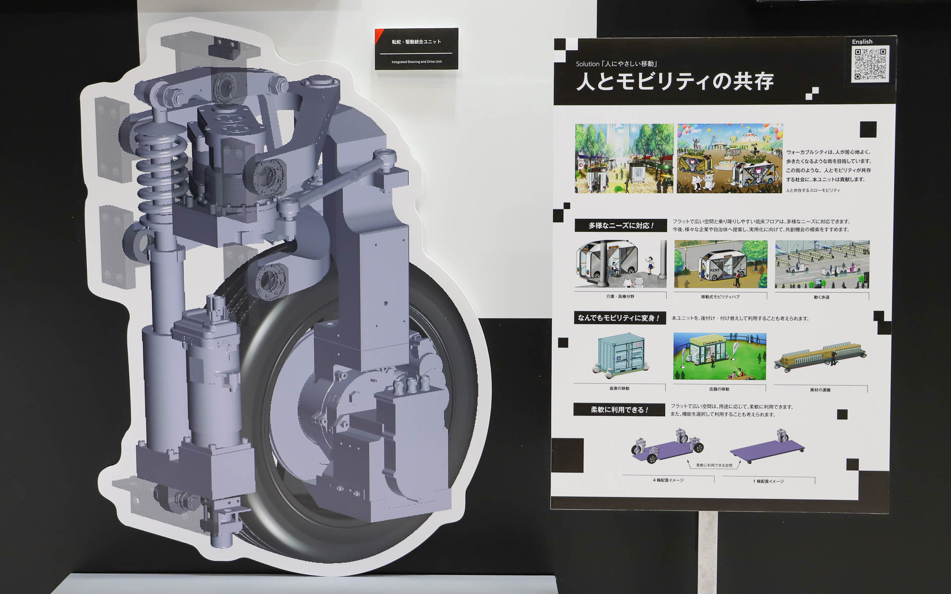 2022年から開発を開始した「走る」「曲がる」「止まる」「下がる」の制御を1つのユニットに集約した「転舵・駆動統合ユニット」。モビリティの四隅に配置することでフロアをフラットにでき、昇降機能も備えることでバリアフリーに貢献する。20～120mmの高さ調整ができ、車両全体の高さを下げるだけでなく、前後・左右のどちらかだけを斜めに傾けたり、降車場などの高さに合わせて自由な位置に調整したりも可能。19km/h以下の低速走行を想定しており、今はまだ手動制御で実証実験段階ではないとしつつ、今後は実証実験が行なえるよう開発を進めていくという