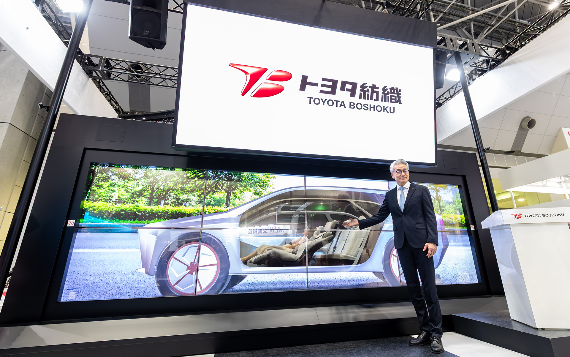 トヨタ紡織株式会社 代表取締役社長・CEO 白柳正義氏と後方に見えているのが次世代の移動空間モック「I.C.30 -Integrated Cabin 2030-」