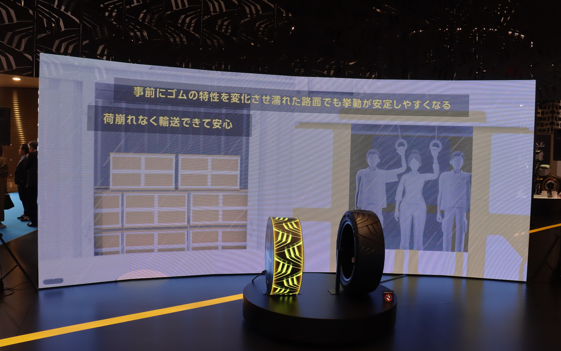 左側に置かれたタイヤ型のディスプレイで、タイヤの特性や形状を事前に最適化させるイメージを表現している