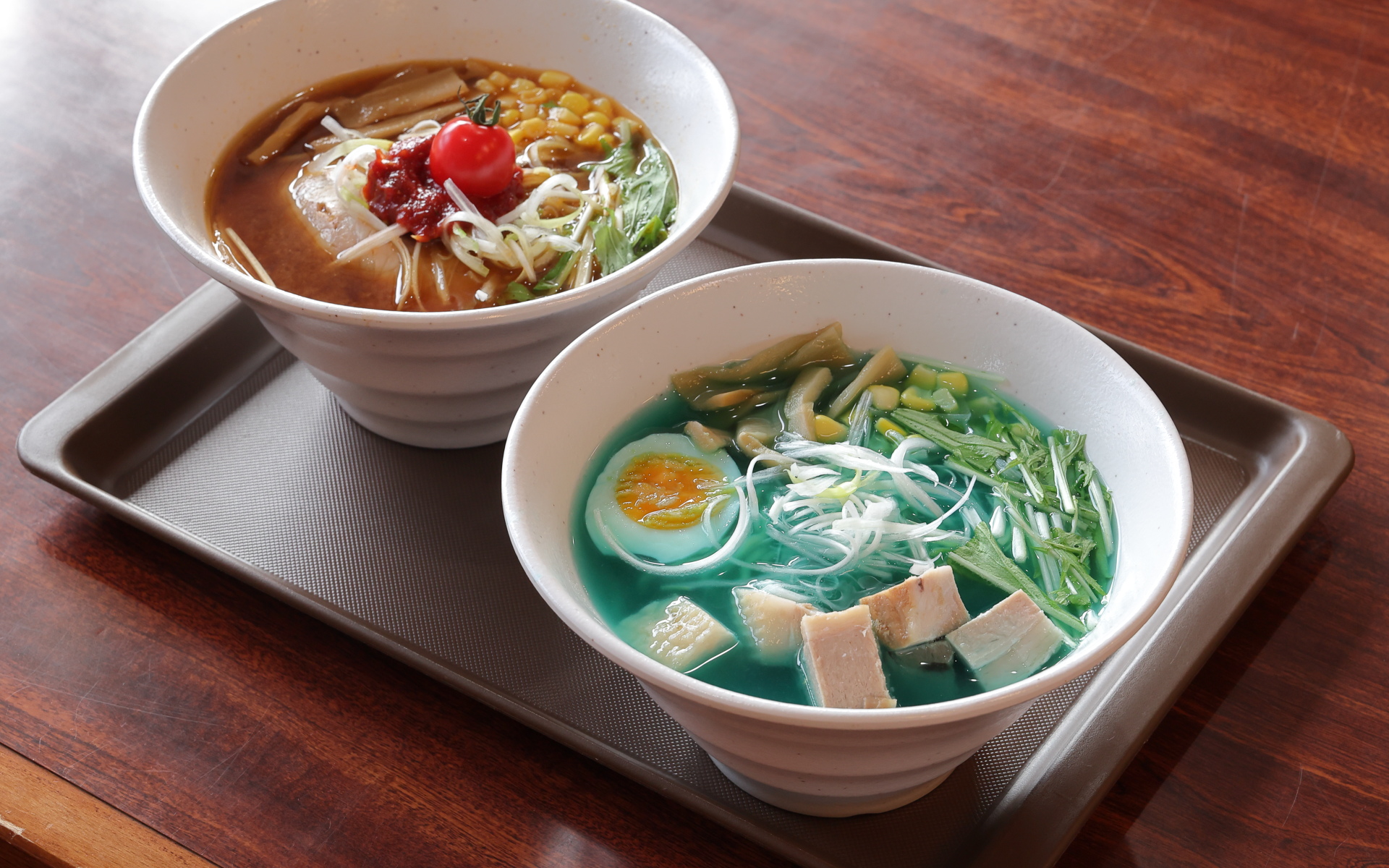 浄土平レストハウスには、青いスープが印象的な「魔女の瞳らぁめん」（手前）以外にも、地元福島のトマトを使った「トマト辛みそらぁめん」（奥）といったメニューも用意されているのでご安心を