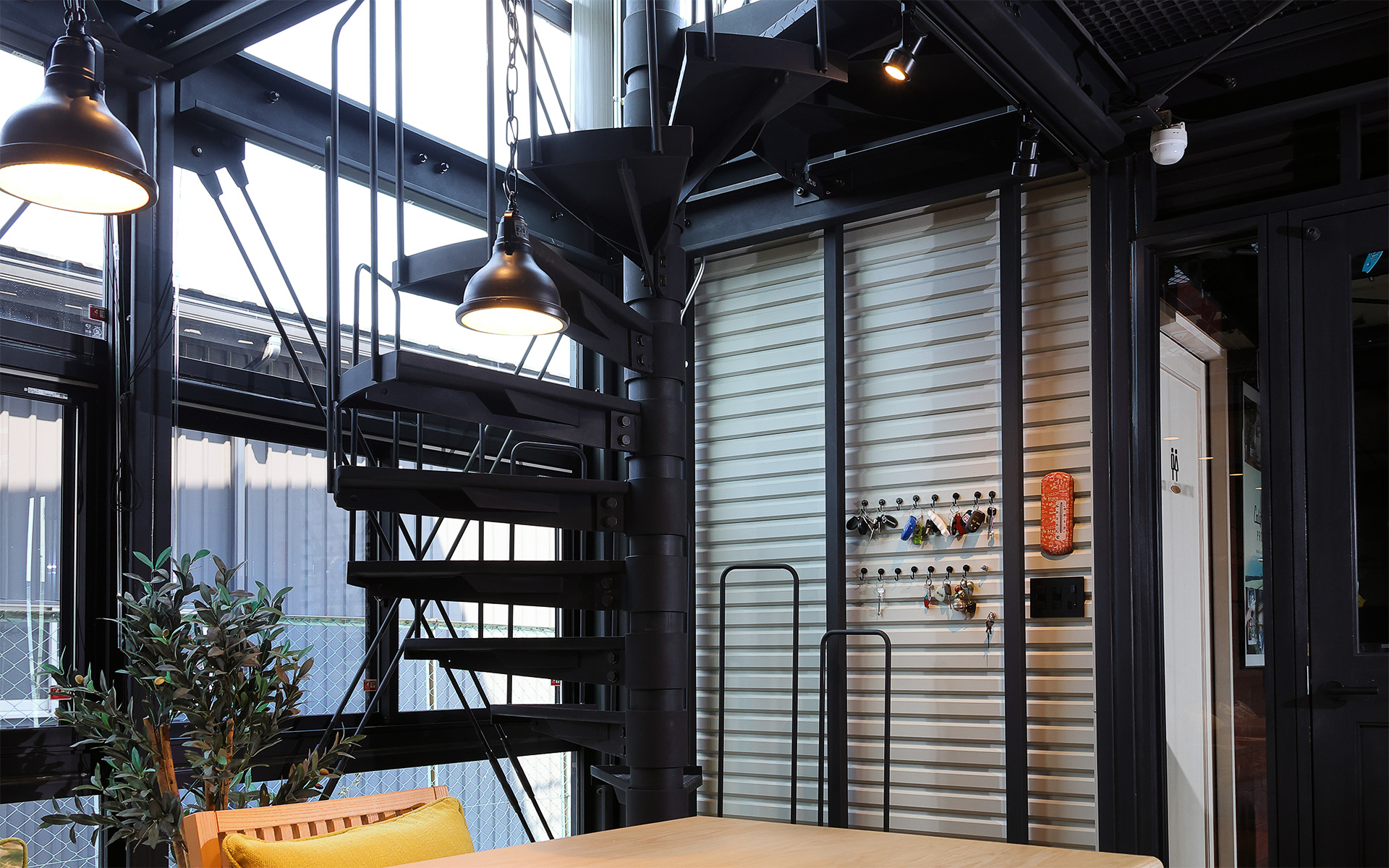 1階部分のリビング。一見して一般住宅のようだが壁際のダブルの筋違い、リズム感ある鉄鋼トラス梁、オリジナル鉄骨製のらせん階段などがあり、一般的な建売住宅とは明確に異なる作り込みがなされている