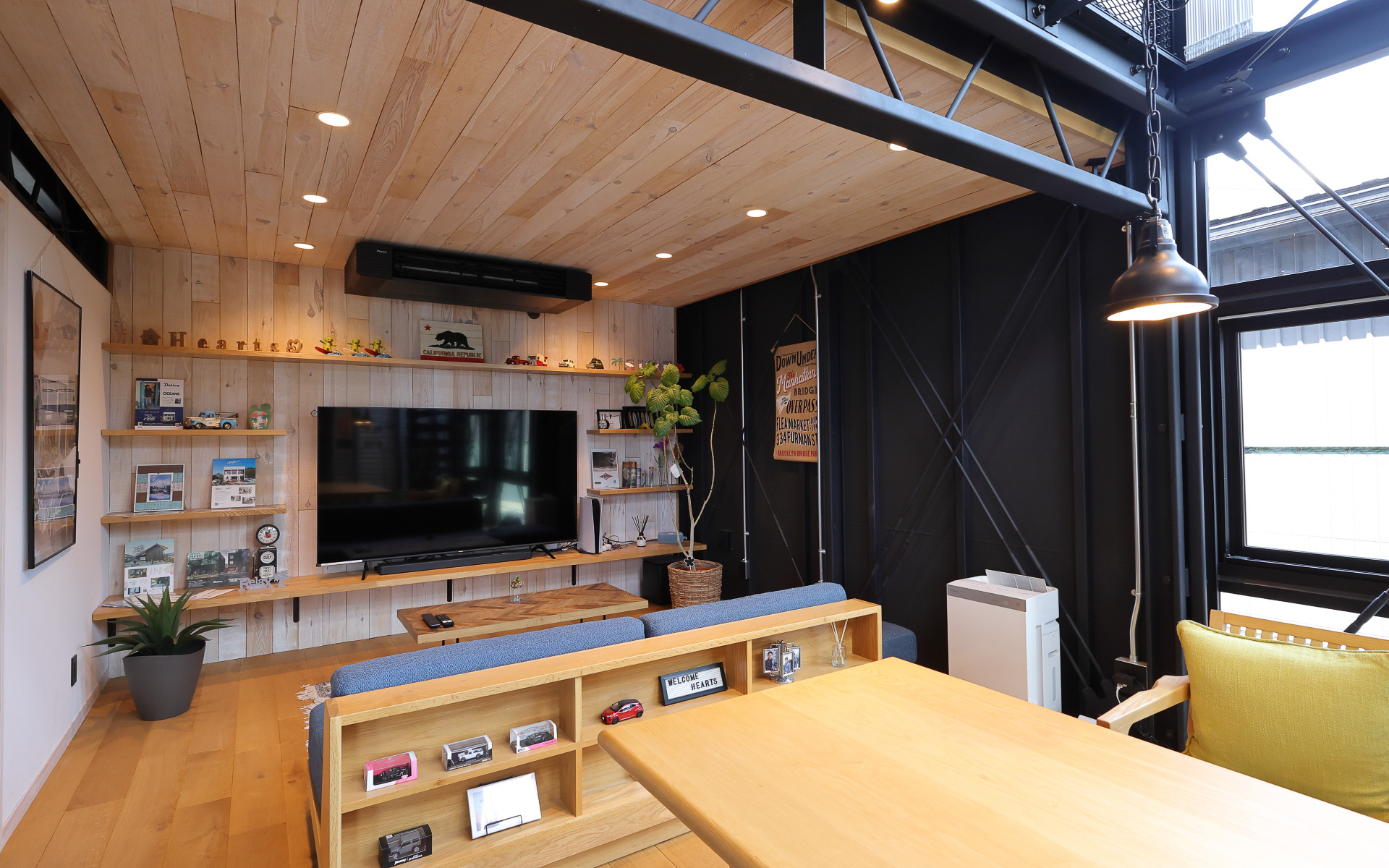 1階部分のリビング。一見して一般住宅のようだが壁際のダブルの筋違い、リズム感ある鉄鋼トラス梁、オリジナル鉄骨製のらせん階段などがあり、一般的な建売住宅とは明確に異なる作り込みがなされている