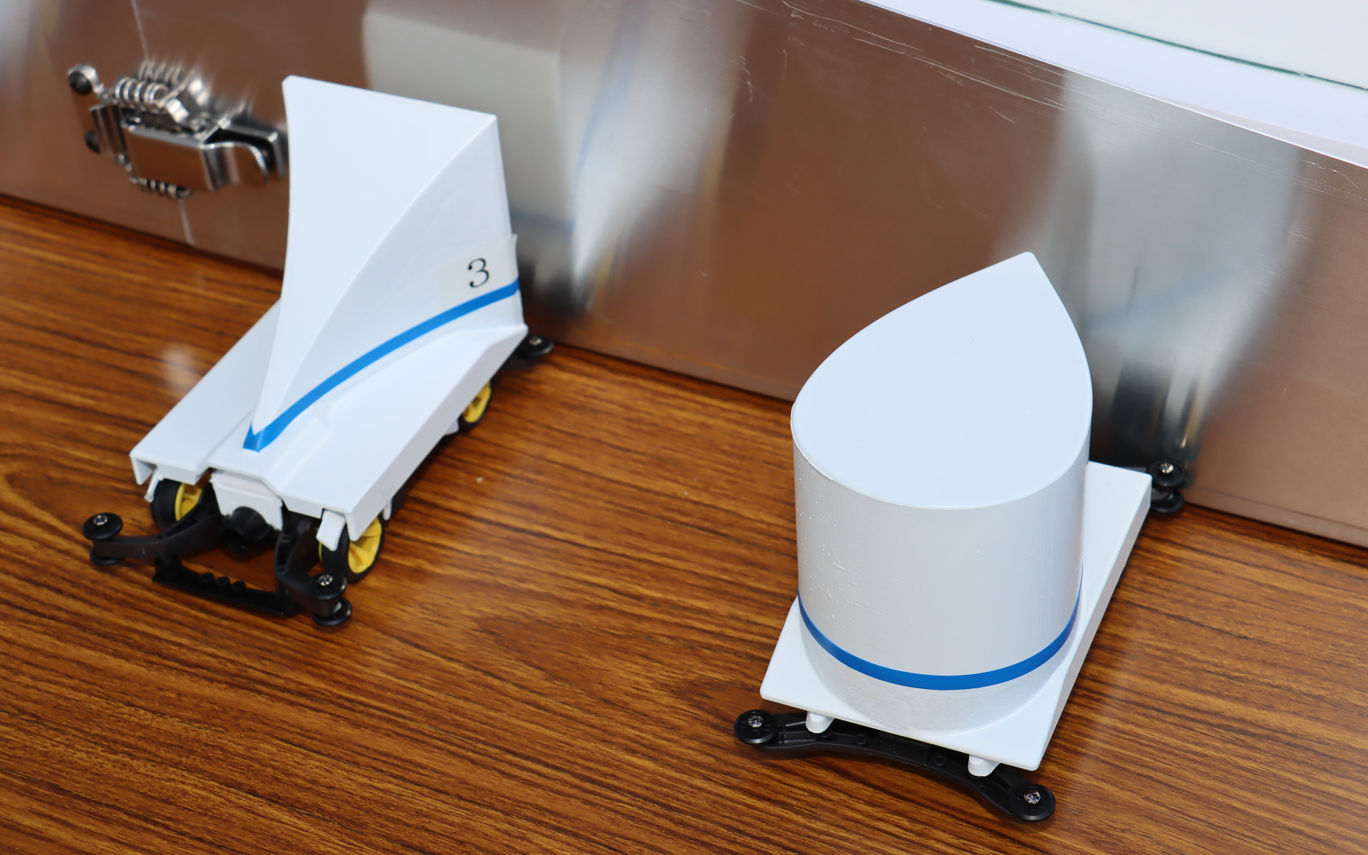 ミニ四駆のシャシーを流用し、重量と前面投影面積を同一条件に合わせ、カウルの形状だけを変更した6種類のマシンを用意。サーキュレーターで強い向かい風を発生させた斜面をどのマシンが一番速く駆け下りるかを予想してもらい、来場者に空気抵抗が車体に与える影響を体感してもらう新たな取り組み