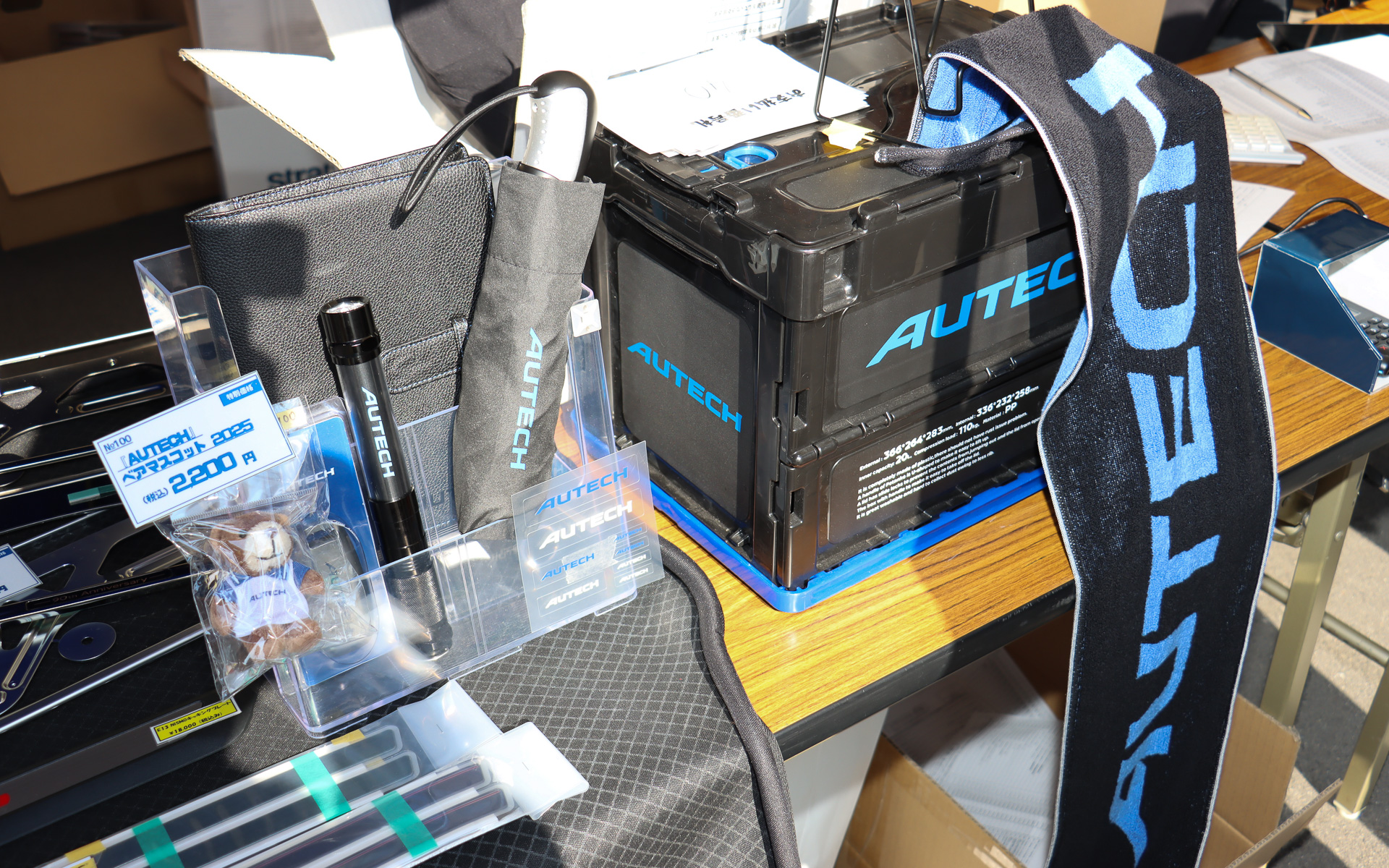 グッズ販売コーナーでは2025年発売のロングタオルや折りたたみ晴雨兼用傘などに加え、190個限定販売の「AUTECH ベアマスコット 2025」も販売