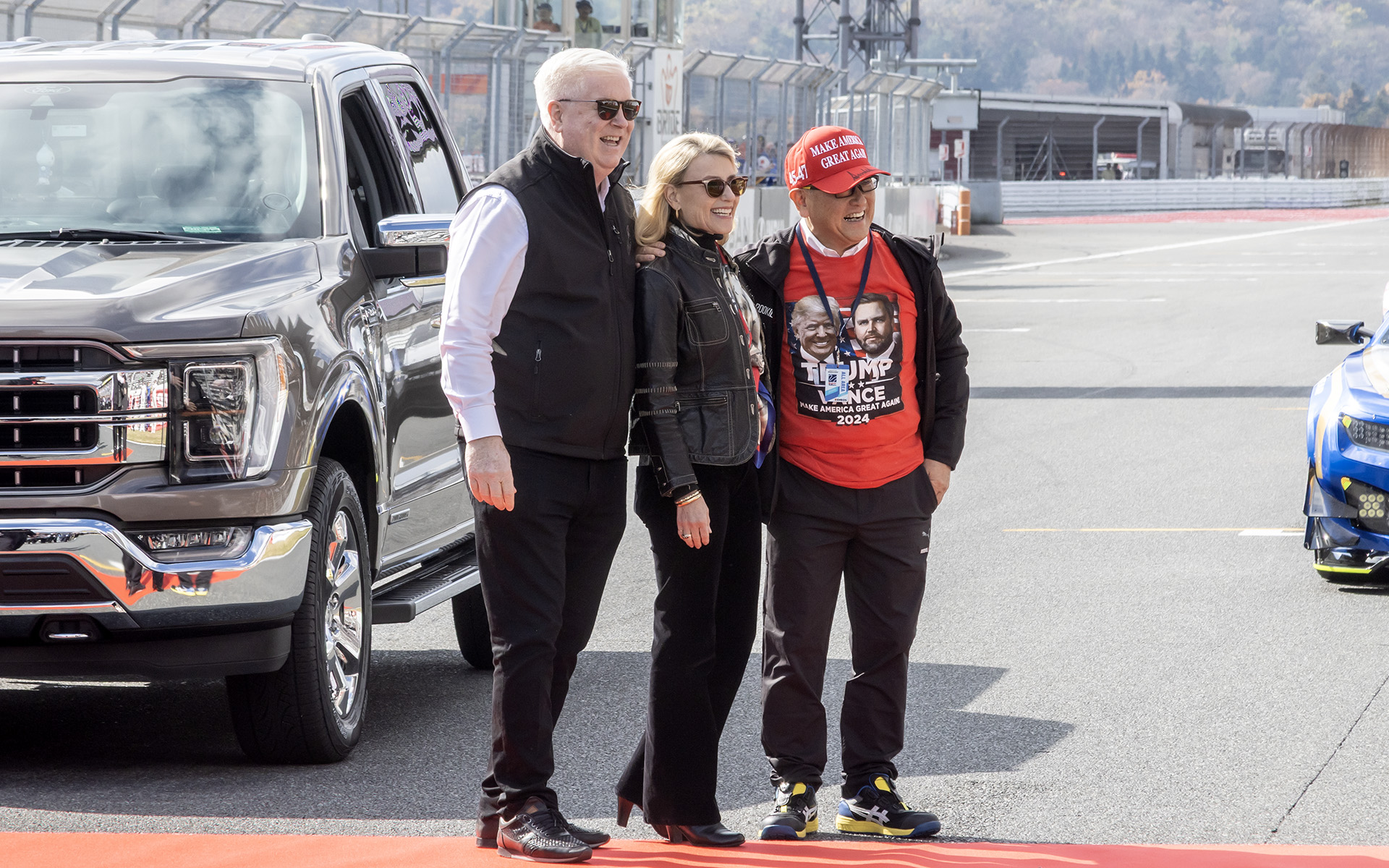 富士スピードウェイの観客に応えるジョージ・グラス駐日米国大使（左）。赤いMAGA（Make America Great Again）キャップをかぶっているのが豊田章男会長