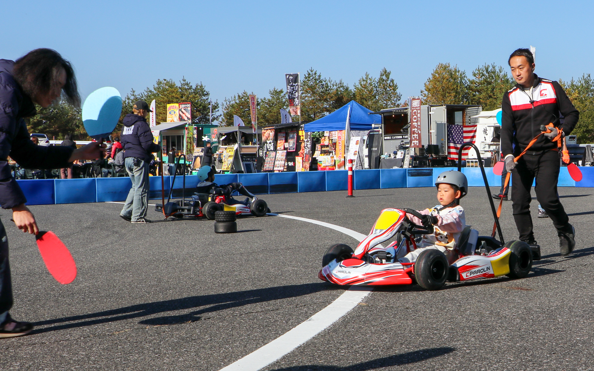 青いウチワがあがったらアクセル、赤いウチワがあがったらブレーキと、スタッフのサインに合わせて操作。伊沢選手も子供たちを楽しませていました