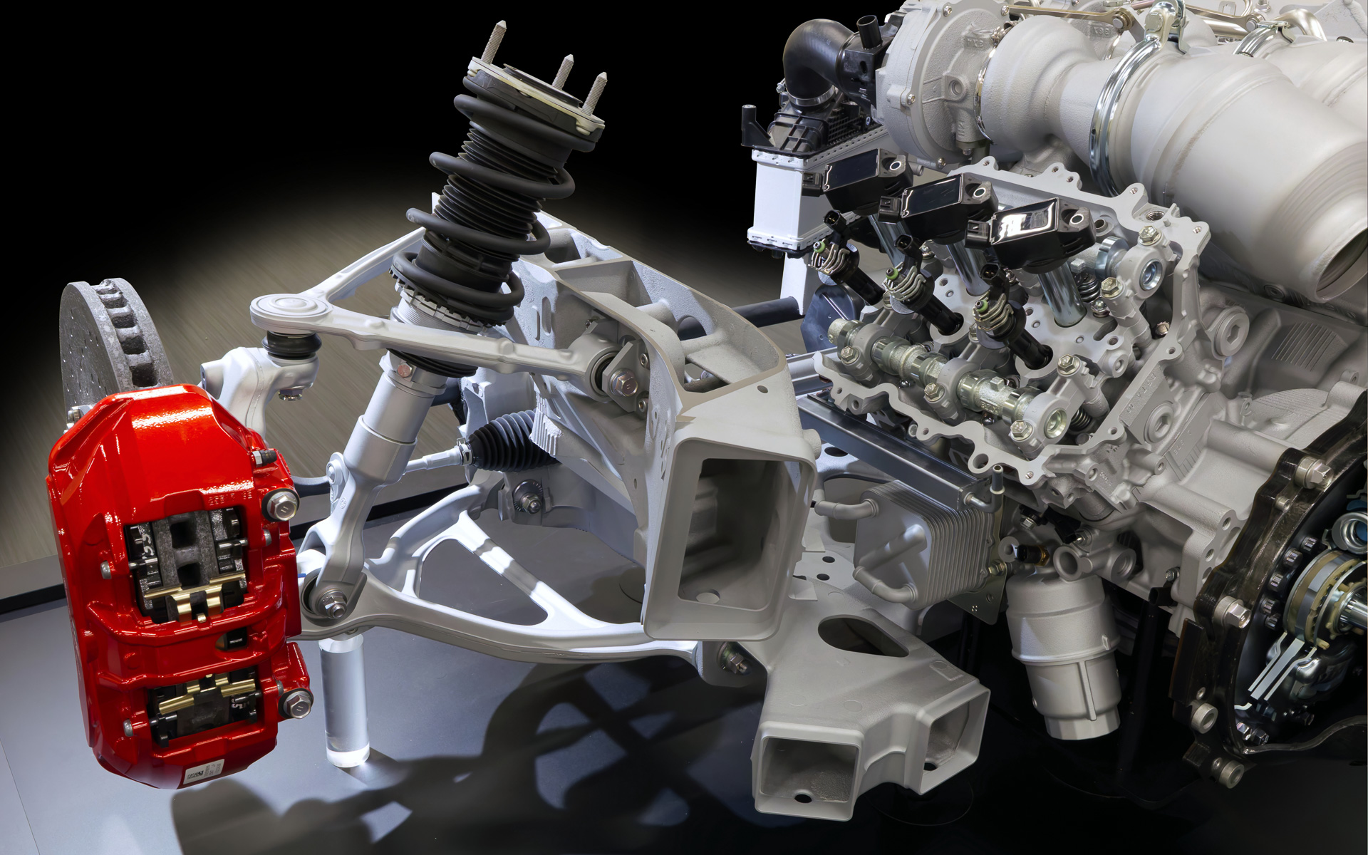 フロントサスペンション部分。ダブルウィッシュボーンがよく分かる。取付部は低圧鋳造のアルミキャスト。ドライサンプエンジンの低重心も刺激的